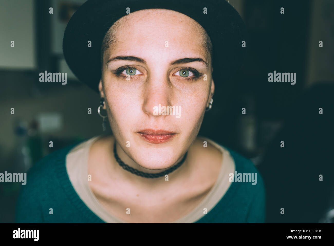Head and shoulder portrait of blue eyed young woman in trilby Stock Photo