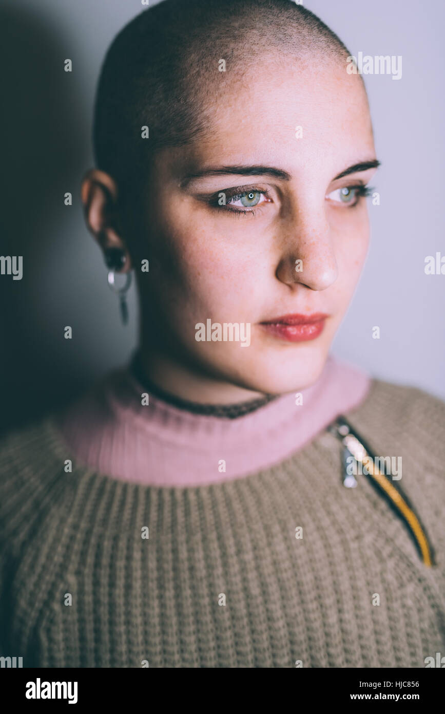 Head and shoulder portrait of blue eyed young woman with shaved head Stock Photo