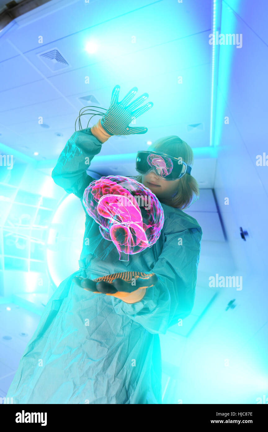Boy in virtual reality headset interacting with digital floating human brain Stock Photo