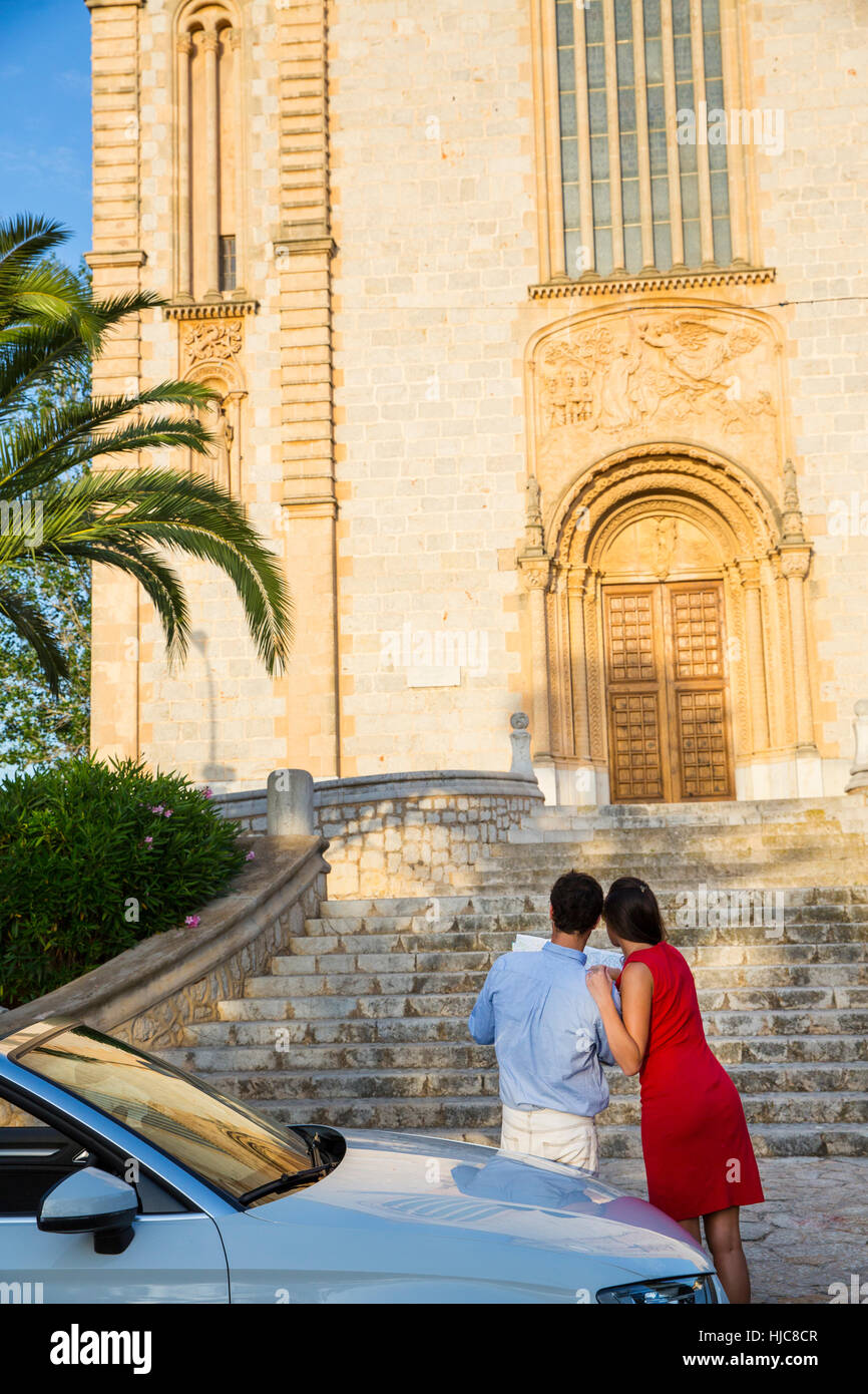 Rear view of young couple with convertible looking at map, Calvia, Majorca, Spain Stock Photo