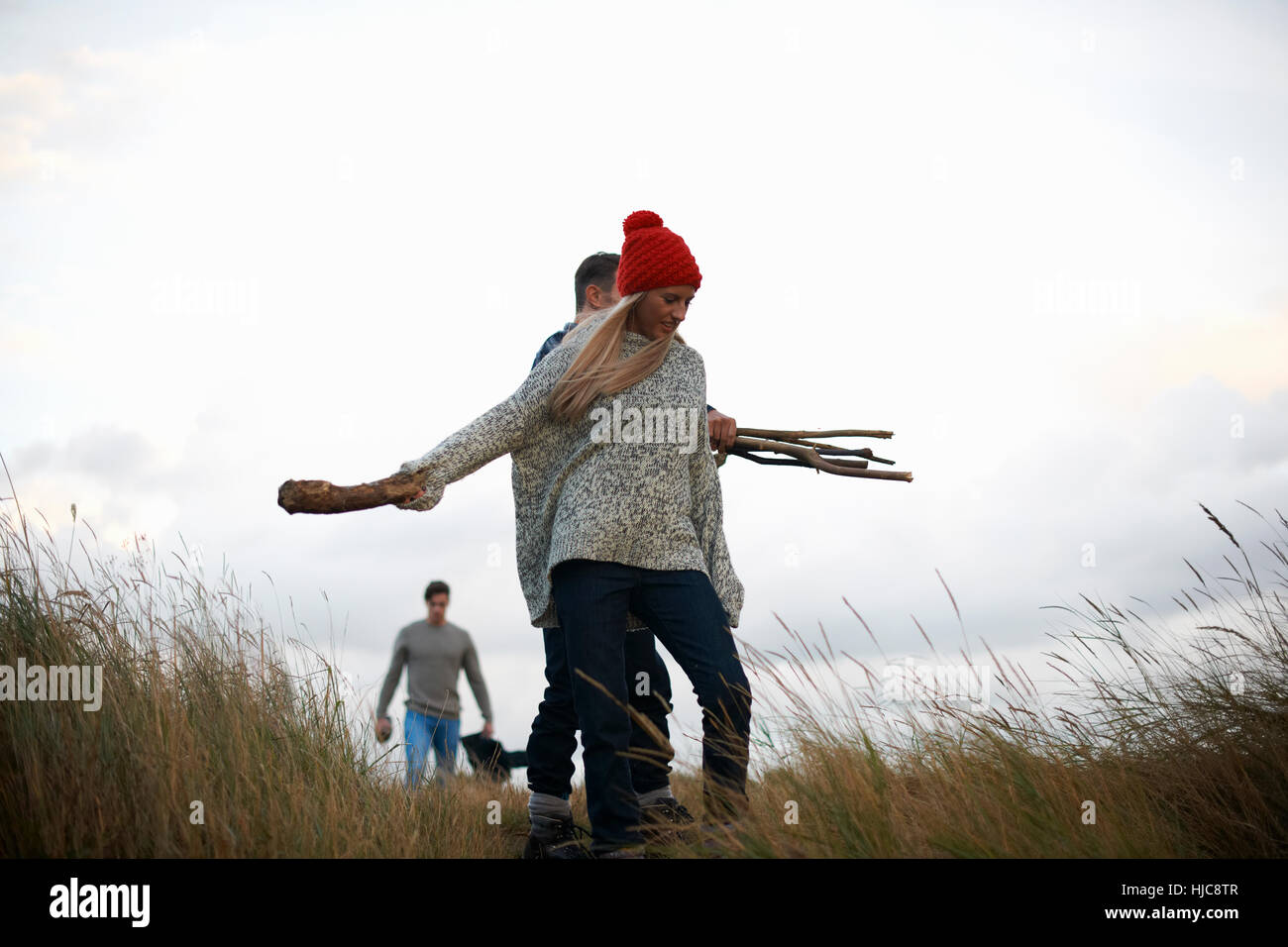 Young adults collecting driftwood in coastal dunes Stock Photo Alamy