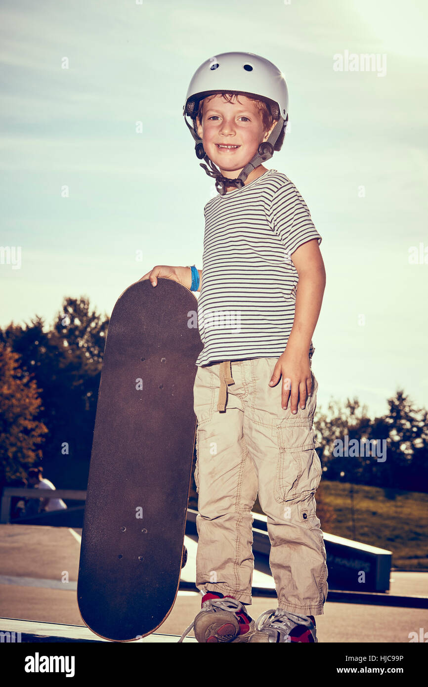 Boy with skateboard in park Stock Photo