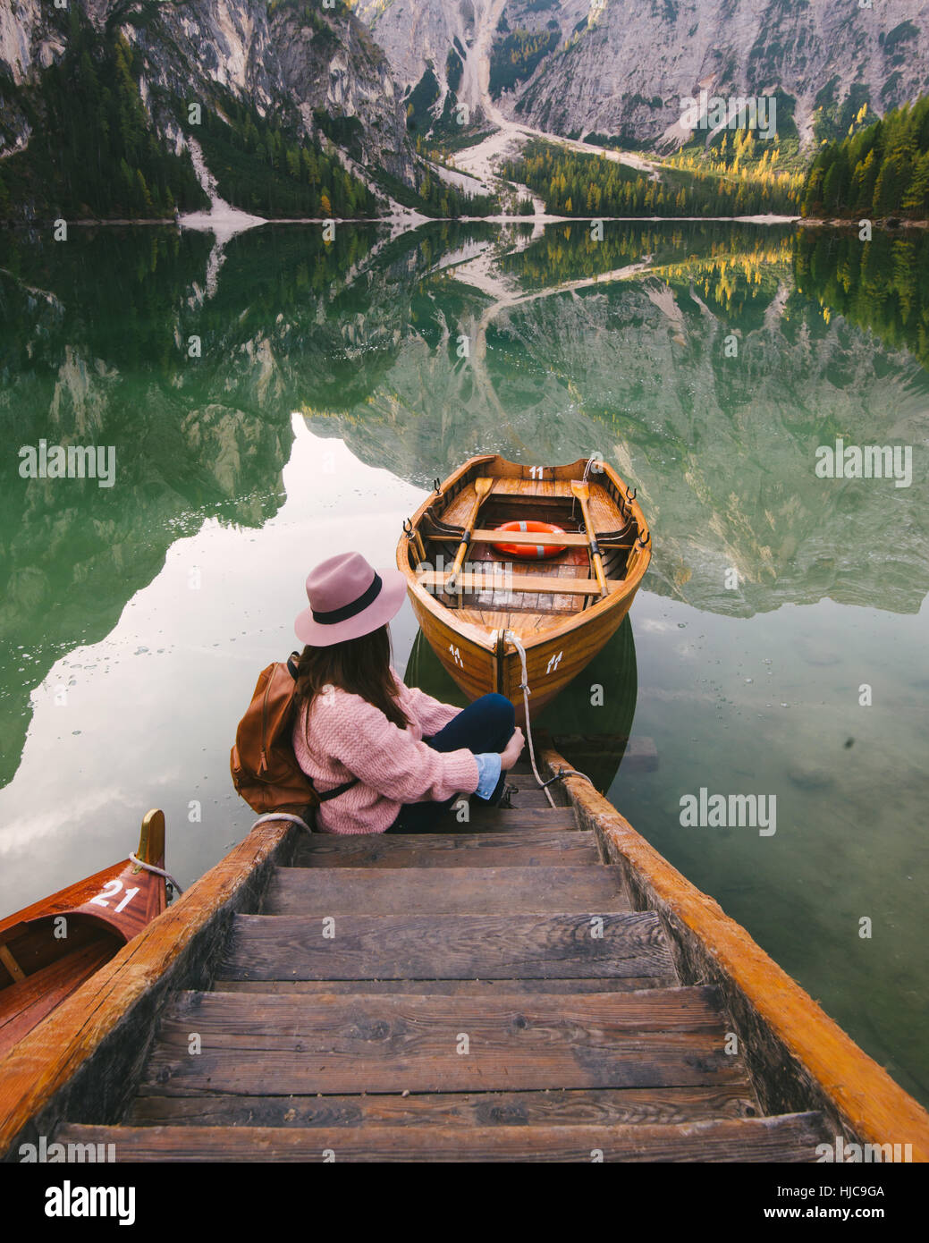 Woman relaxing on pier, Lago di Braies, Dolomite Alps, Val di Braies, South Tyrol, Italy Stock Photo