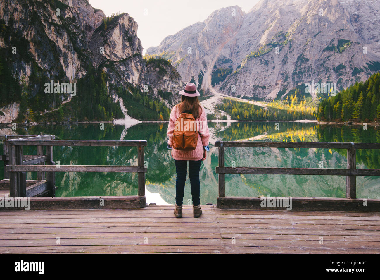 Woman enjoying view on pier, Lago di Braies, Dolomite Alps, Val di Braies, South Tyrol, Italy Stock Photo