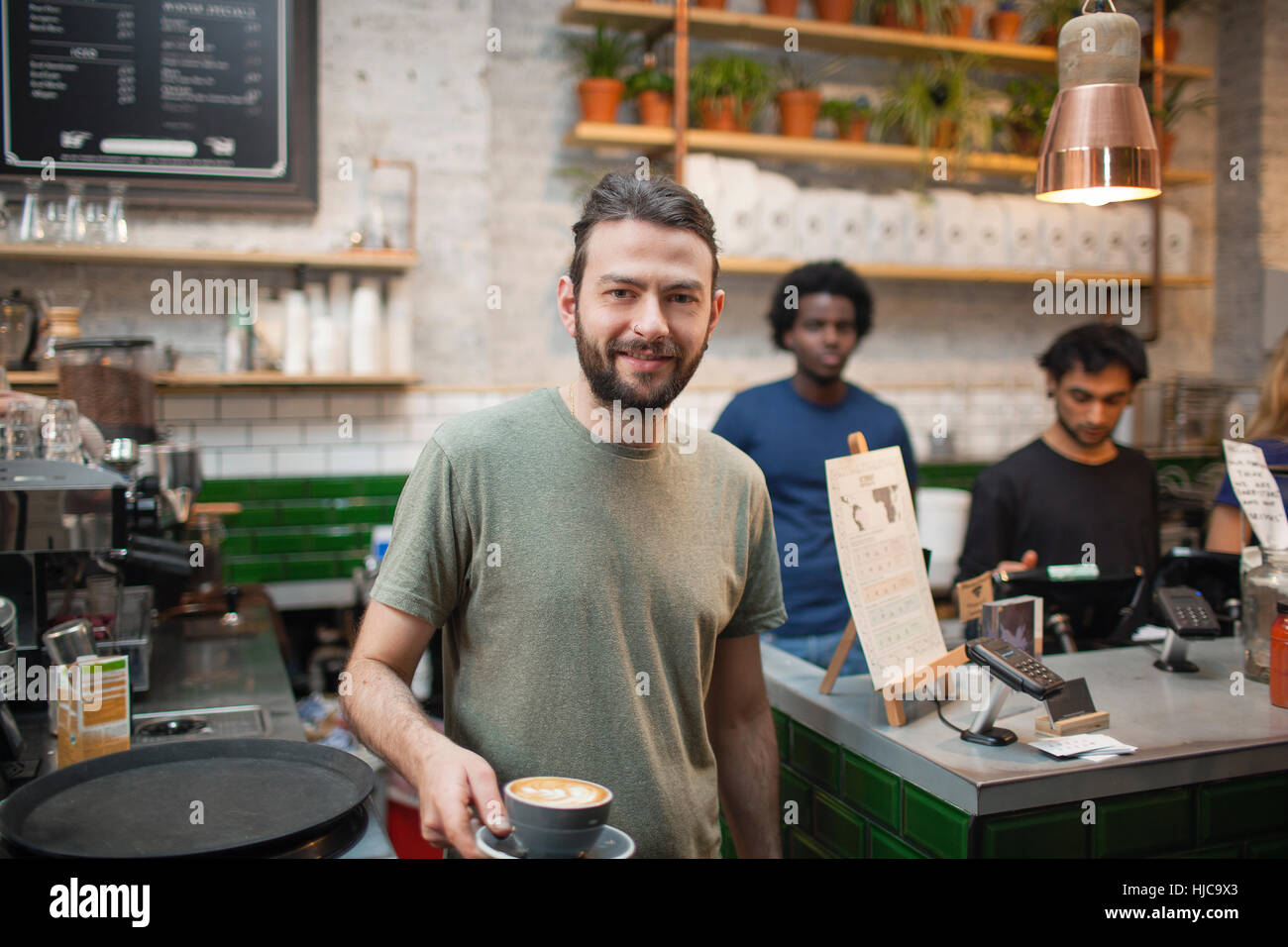 Portrait of male barista serving coffee in cafe Stock Photo Alamy