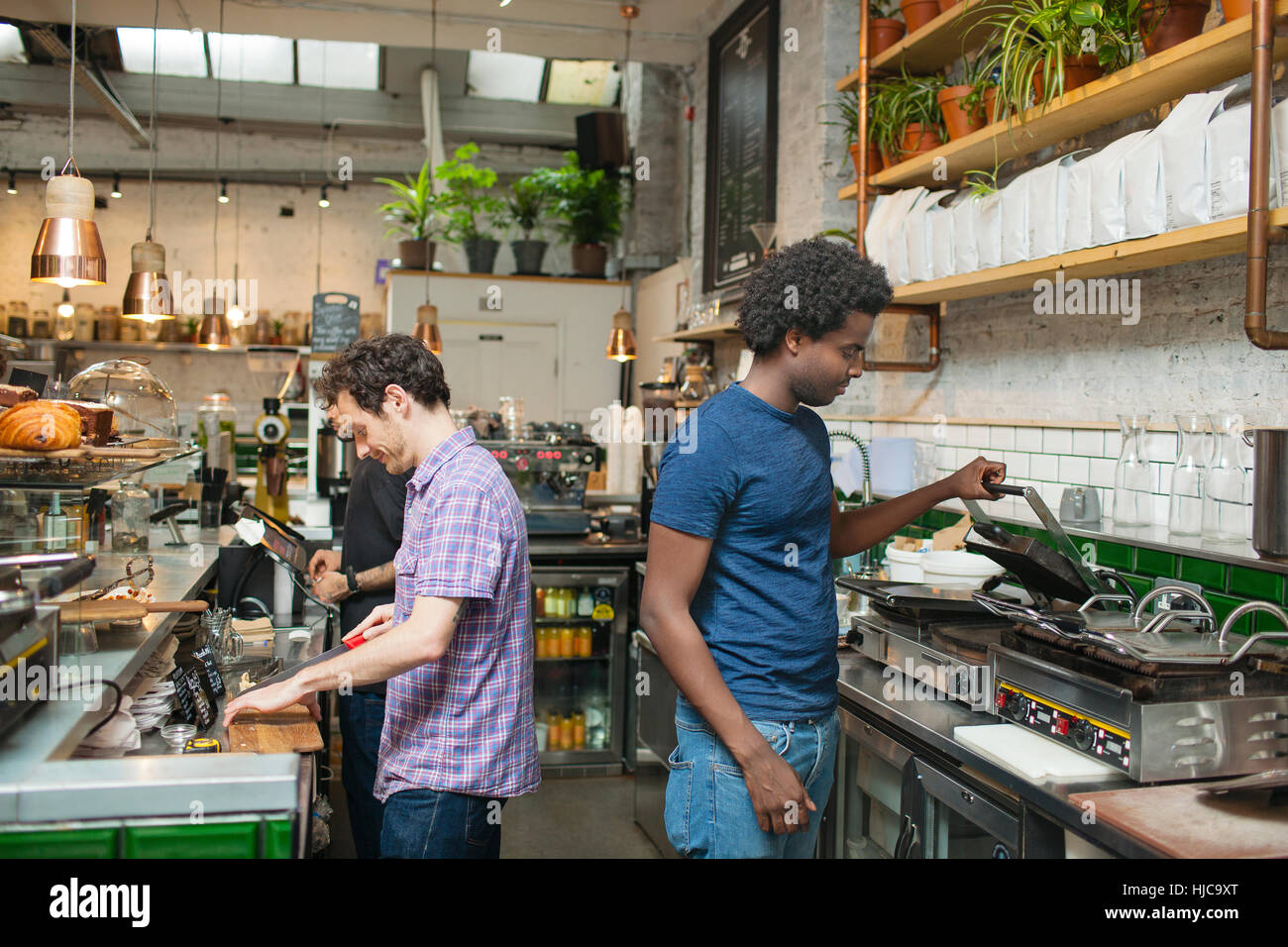 Two waiters preparing food in cafe kitchen Stock Photo