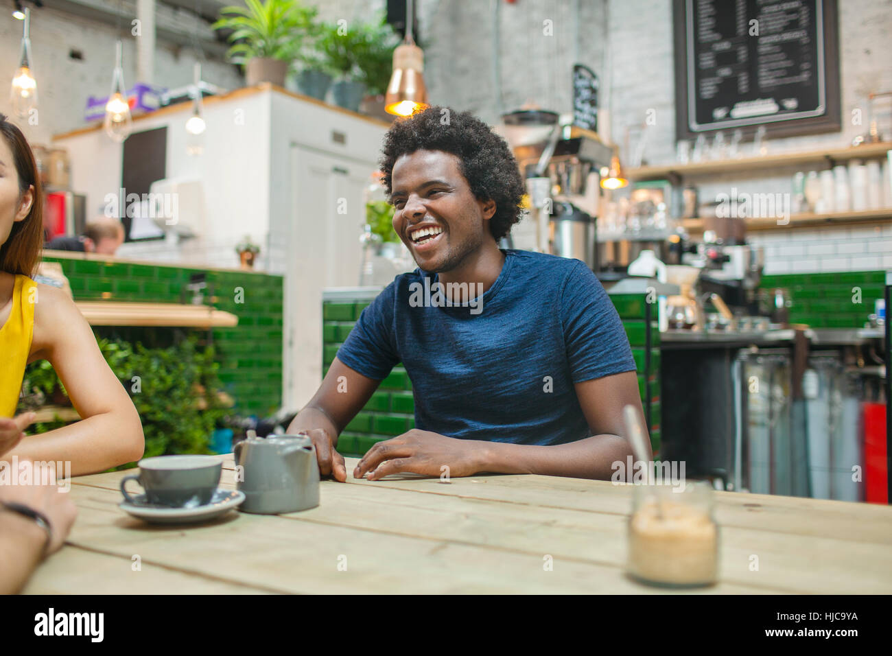 Woman and male friends chatting together in cafe Stock Photo