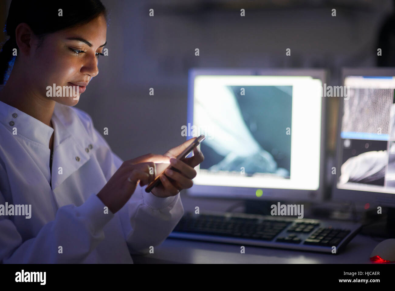 Scientist in laboratory texting on smartphone Stock Photo - Alamy