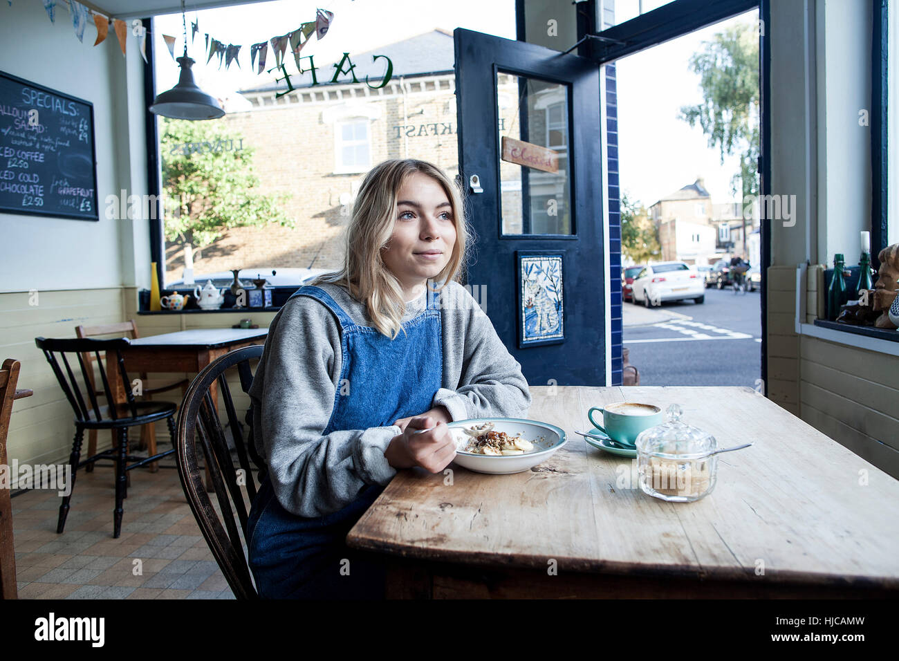 Young woman in cafe, eating muesli Stock Photo