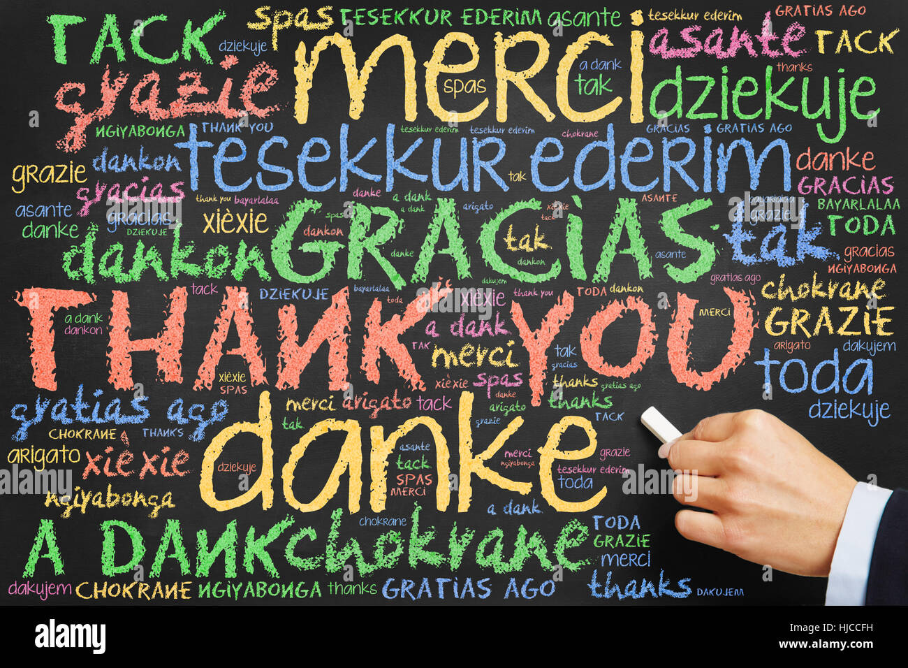 Je M'en Remettrai Merci En Anglais Hand writing "Thank you" in many languages on a chalkboard Stock Photo