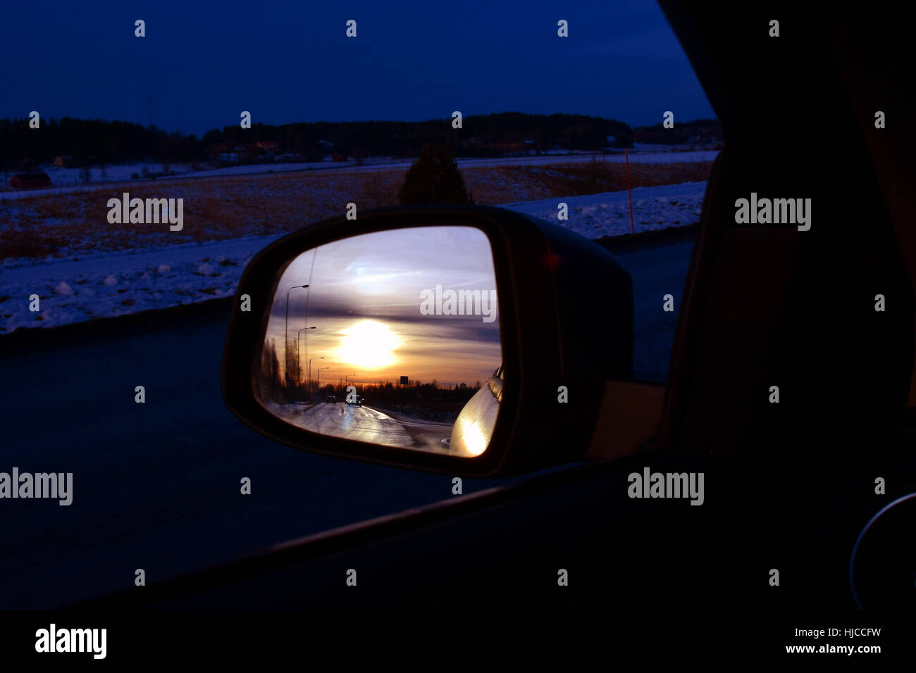 Sunset reflected in car side-view mirror. Stock Photo