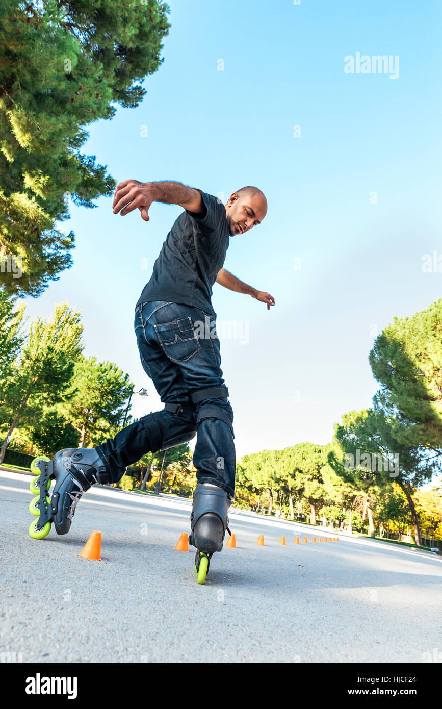 Urban young man on roller skates on the road at summer time. Roller