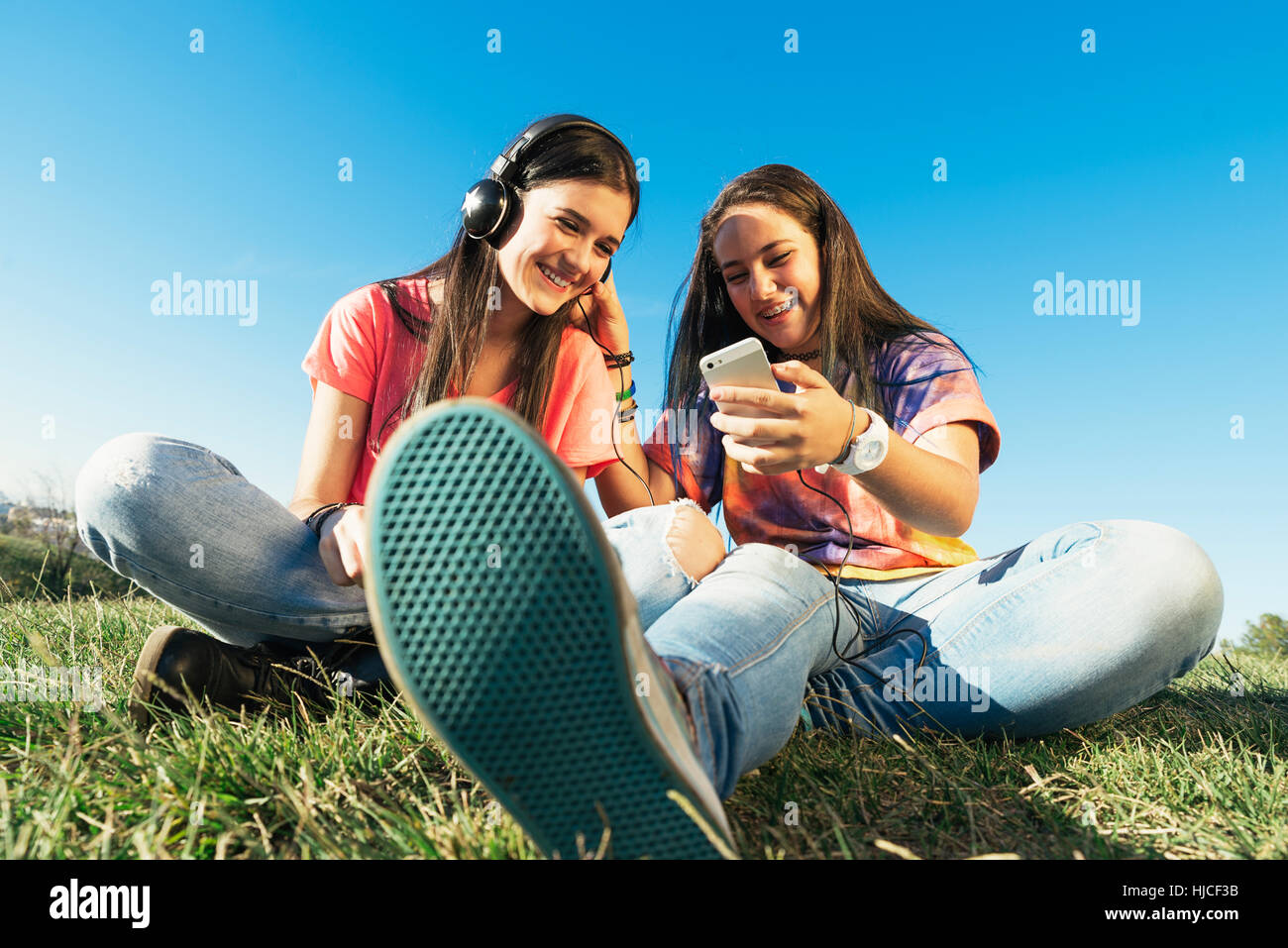 happy beautiful teen friends in summer park listening music Stock Photo ...