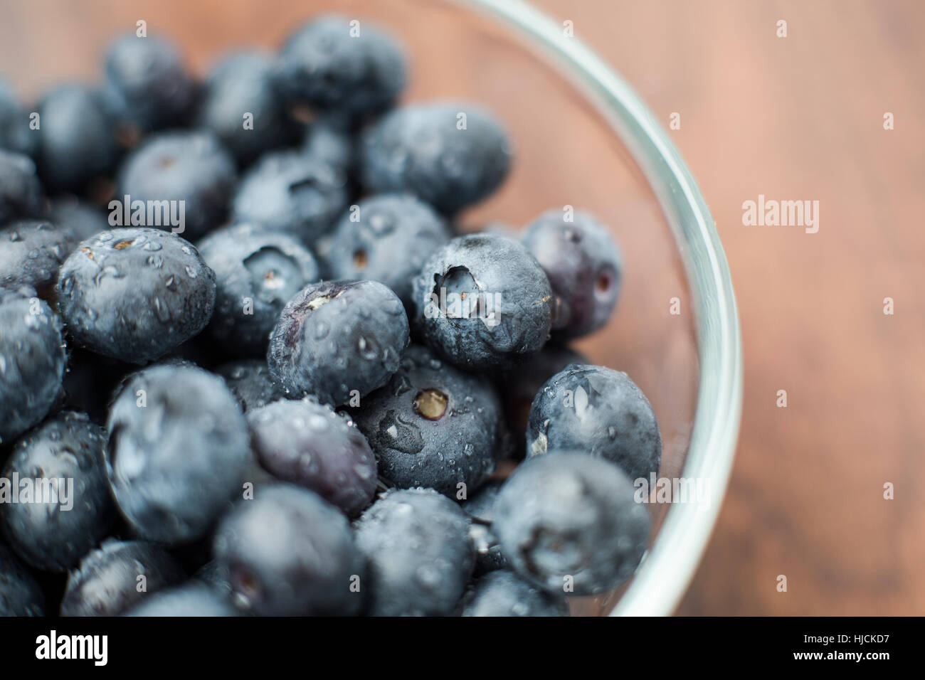 A glass bowl piled with fresh organic blueberries Stock Photo