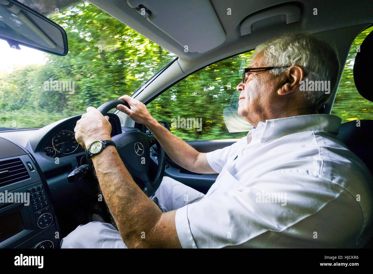 Retired man, early 70s, in driving seat of 4x4 car, SUV England UK