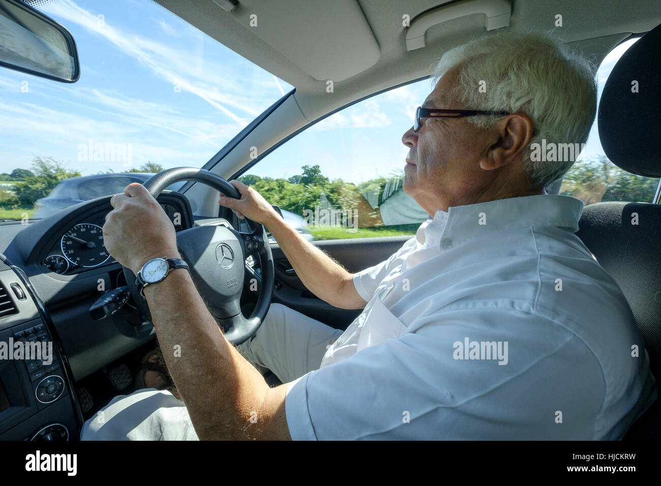 Retired man, early 70s, in driving seat of 4x4 car, SUV England UK Stock Photo