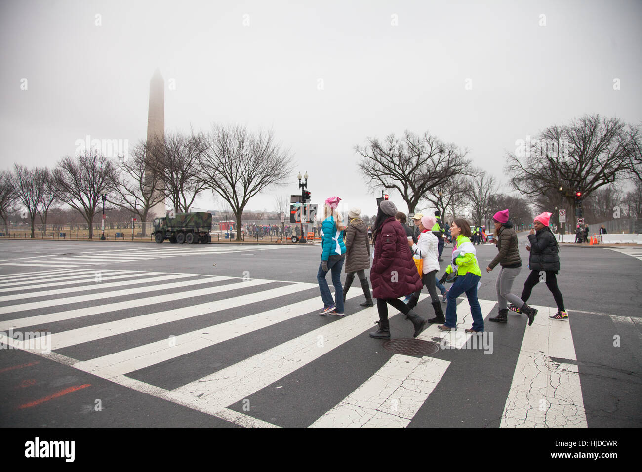 Washington, USA. January 21st, 2017. Women's March on Washington, DC: Group of women crossing the street on Constitution Avenue with the Washington Monument bathed in fog in the background to make their way to the rally to protest President Trump's positions on women's and other human rights. Credit: Dasha Rosato/Alamy Live News Stock Photo