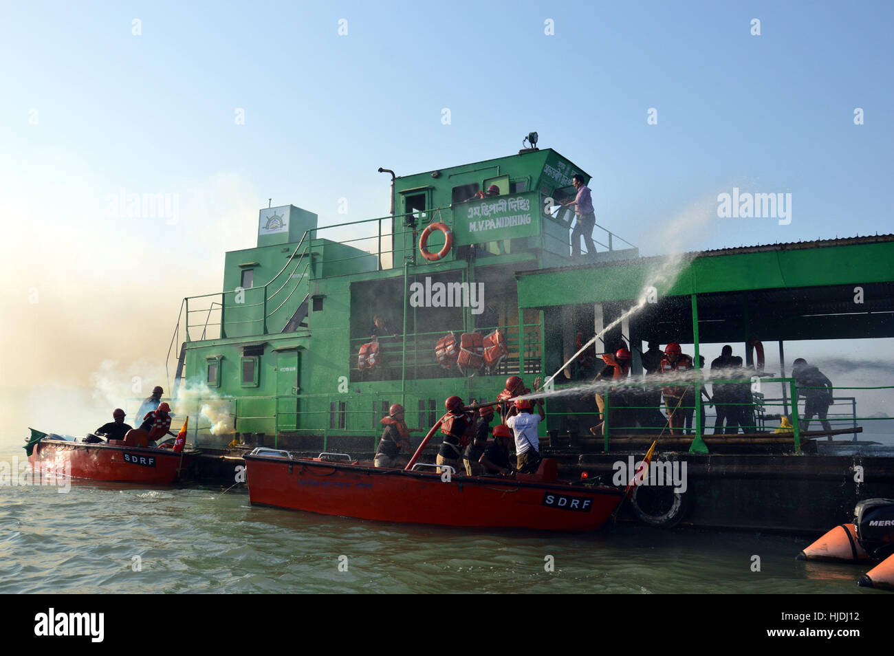 Guwahati, India. 25th January 2017. SDRF and Fire emergency service personnel performing Mock Drill demonstration of Fire Fighting and Rescue in a Burning Ship at the heart of river Brahmaputra in Guwahati on 25-01-17. Credit: Abhijit Bose/Alamy Live News Stock Photo