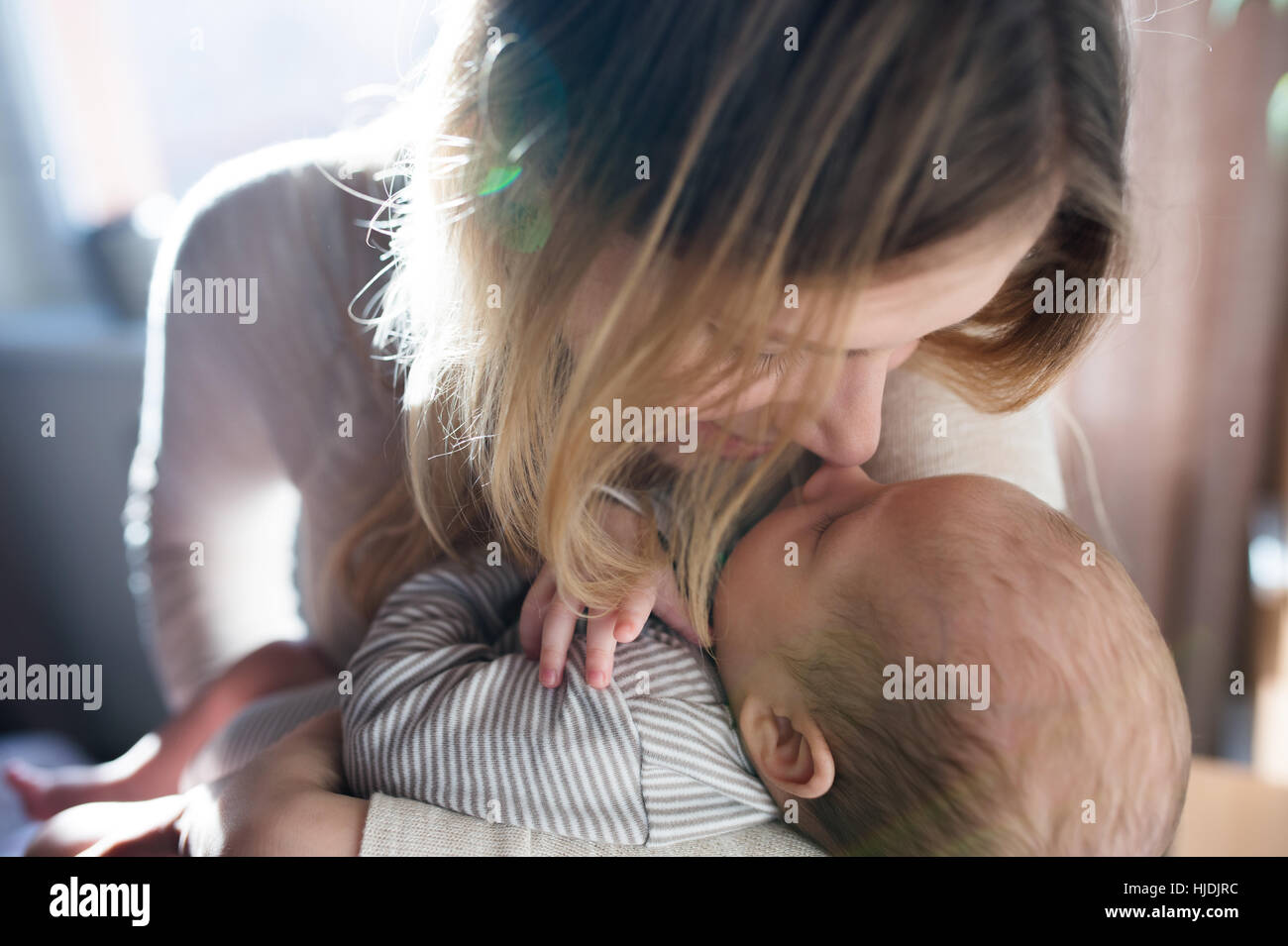 Beautiful young mother holding baby son in her arms Stock Photo - Alamy
