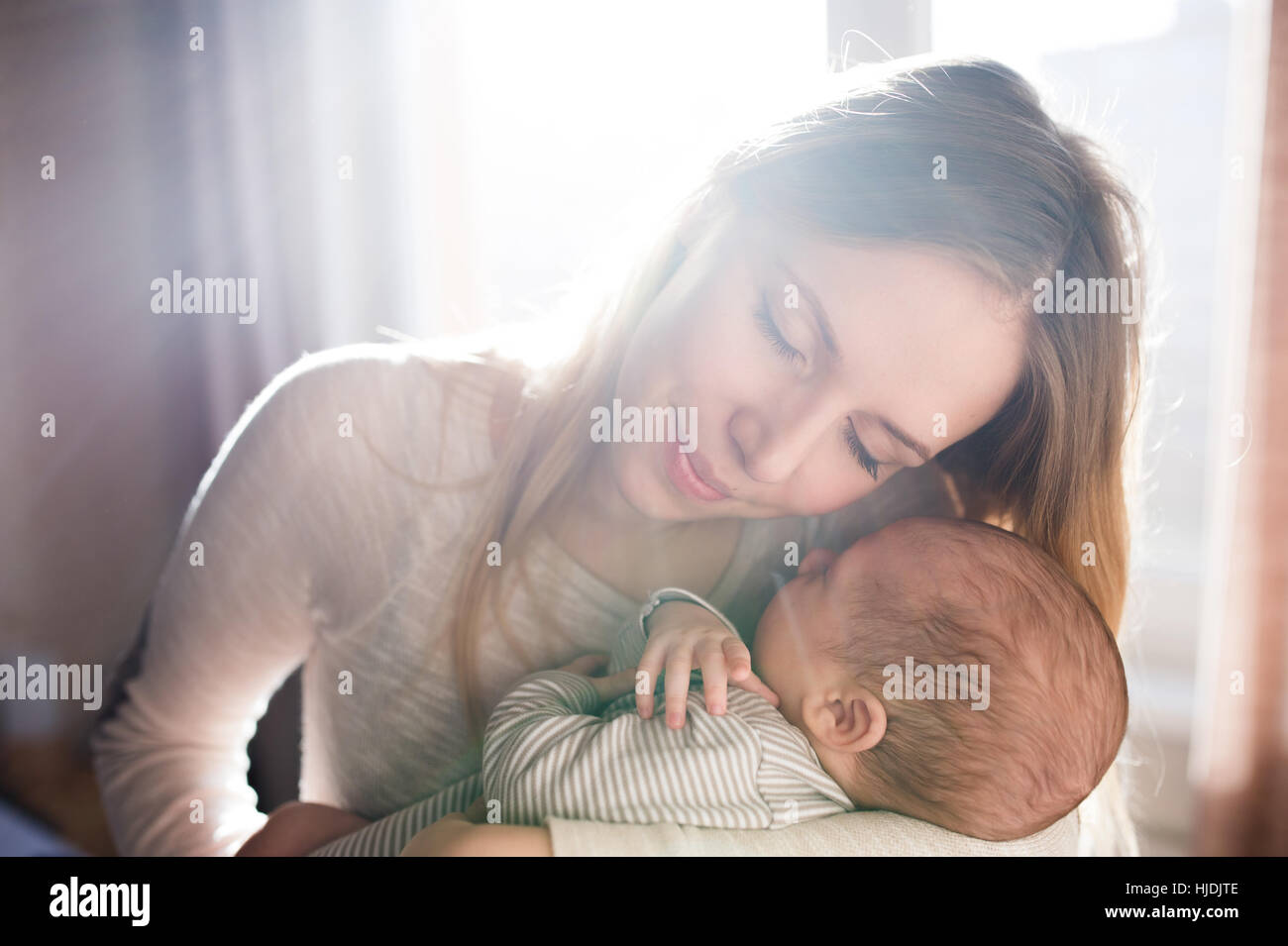 Beautiful young mother holding baby son in her arms Stock Photo - Alamy