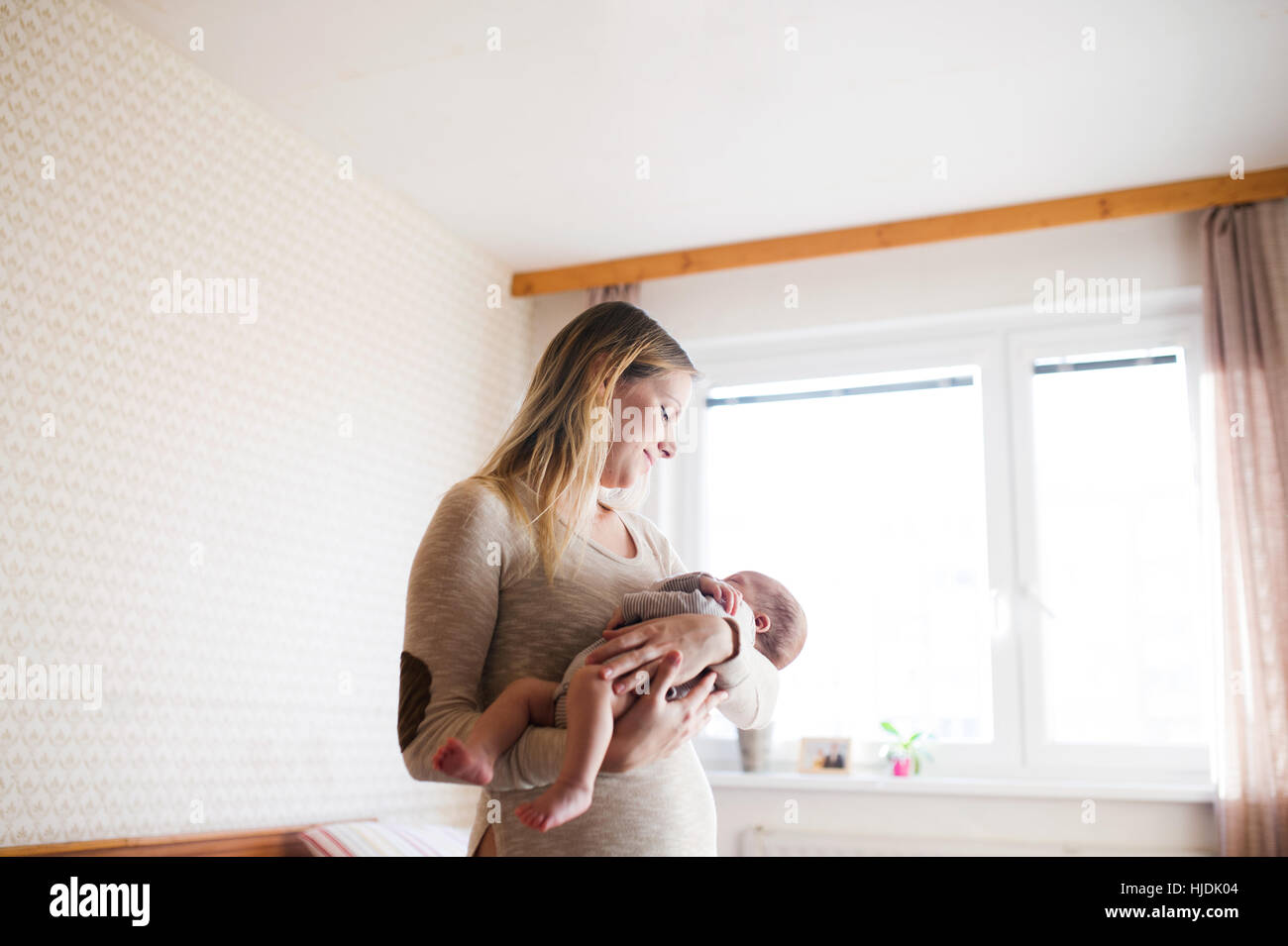 Beautiful young mother holding baby son in her arms Stock Photo - Alamy