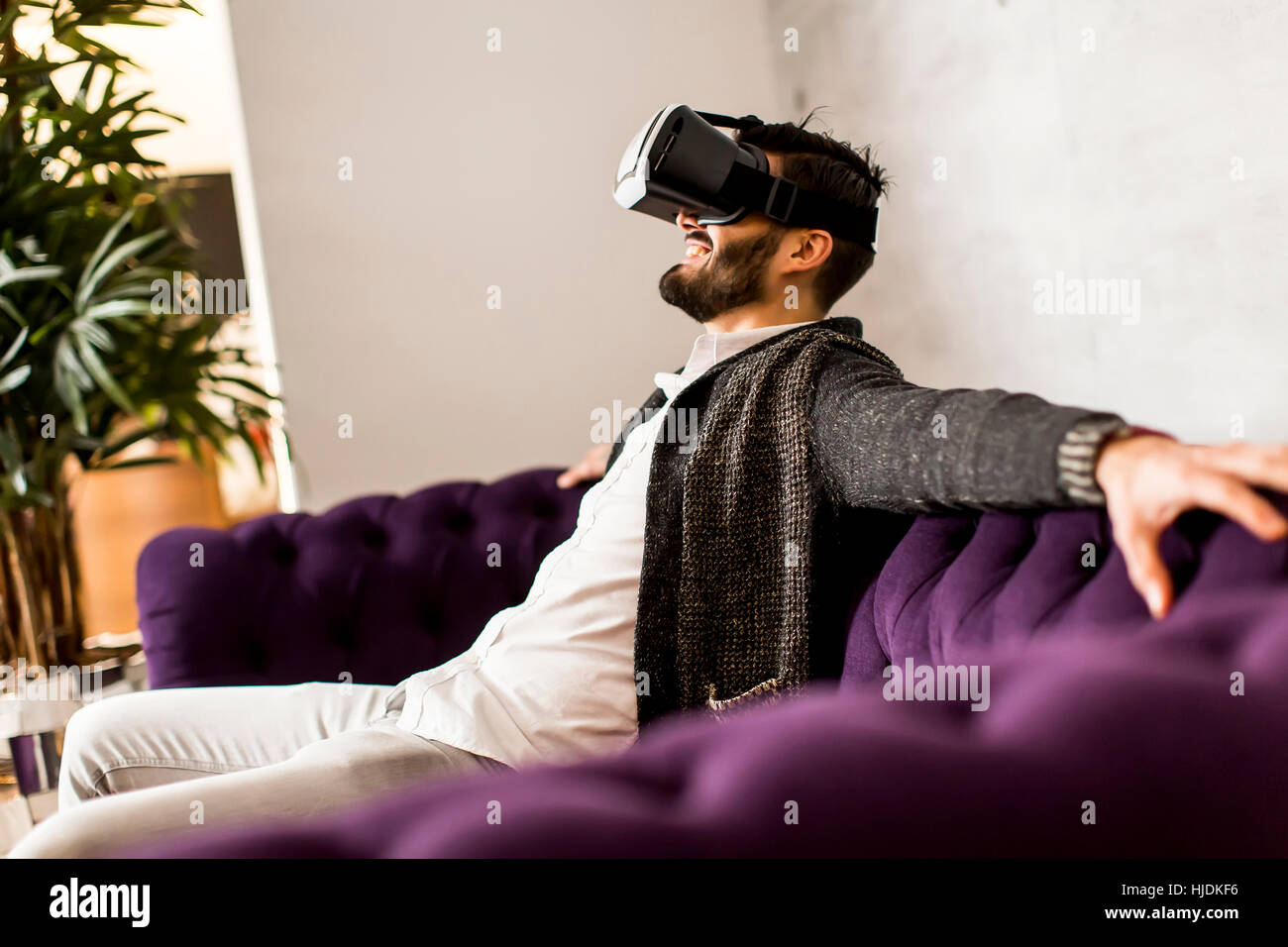 Bearded young man wearing virtual reality goggles in modern room Stock ...