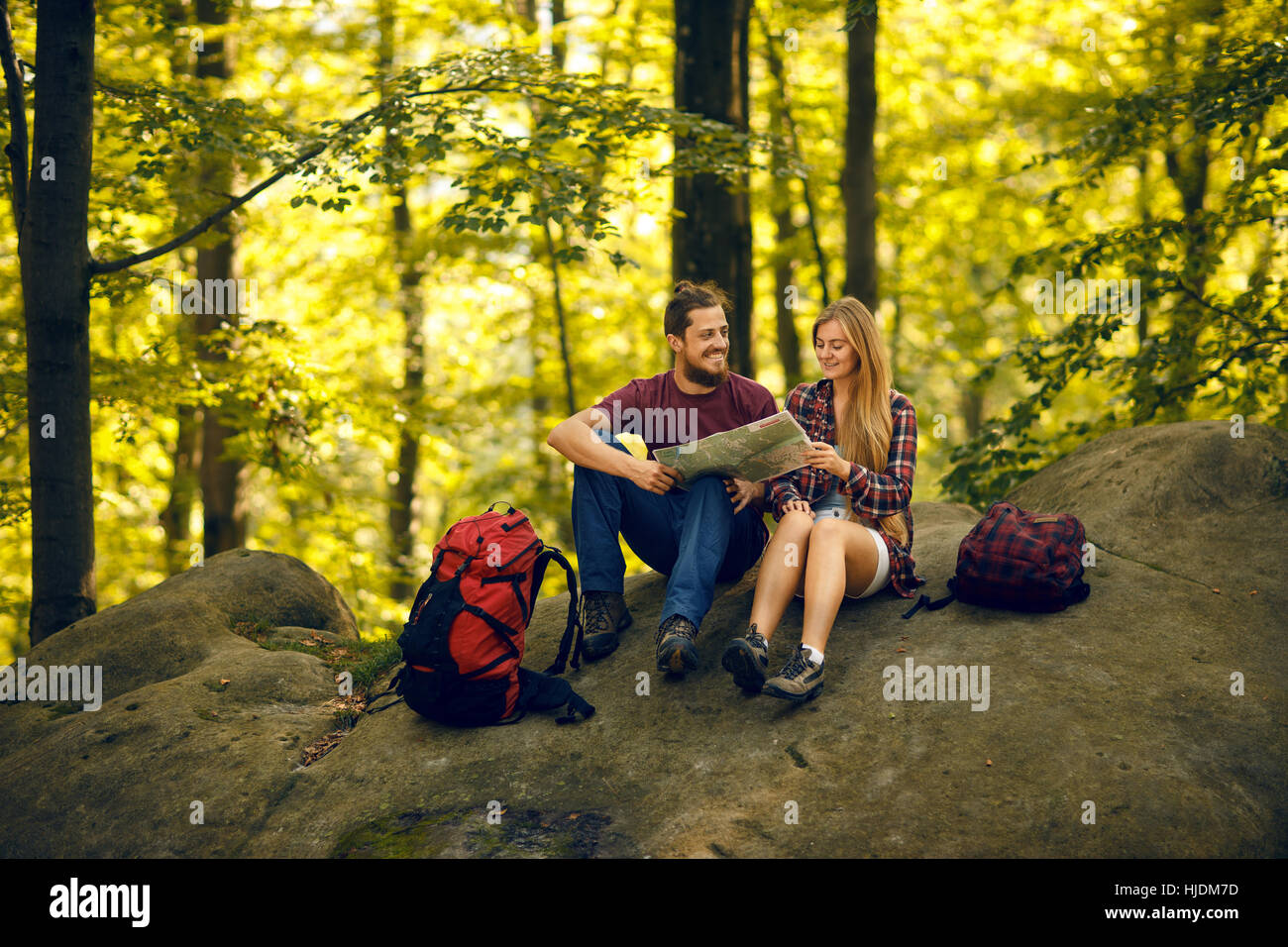 Students seating on the rock in the forest and looking on the map Stock ...