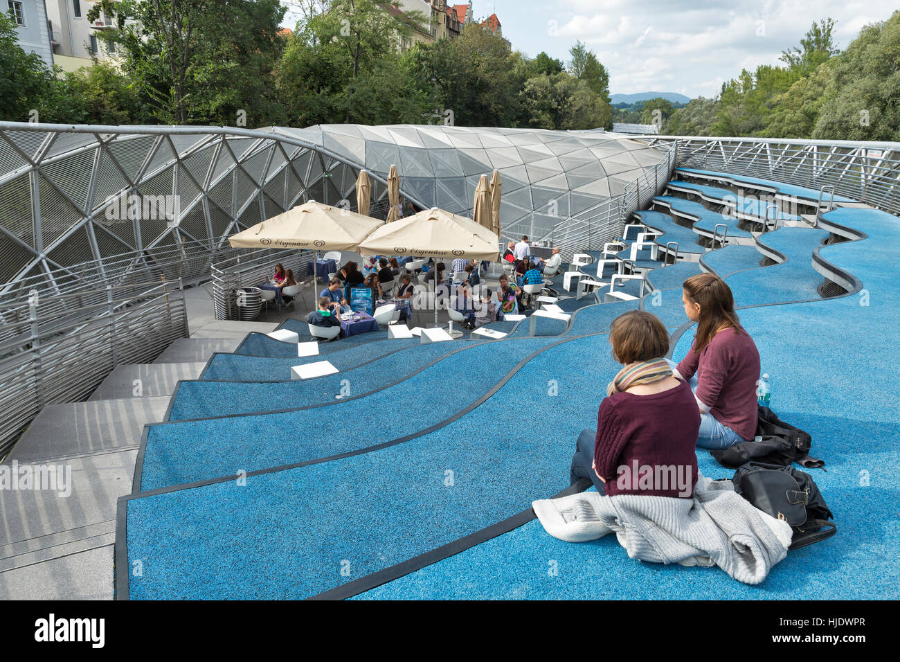 GRAZ, AUSTRIA - SEPTEMBER 11, 2015: People visit Insel Cafe on the artificial island Murinsel on the Mur river, designed by American architect Vito Ac Stock Photo