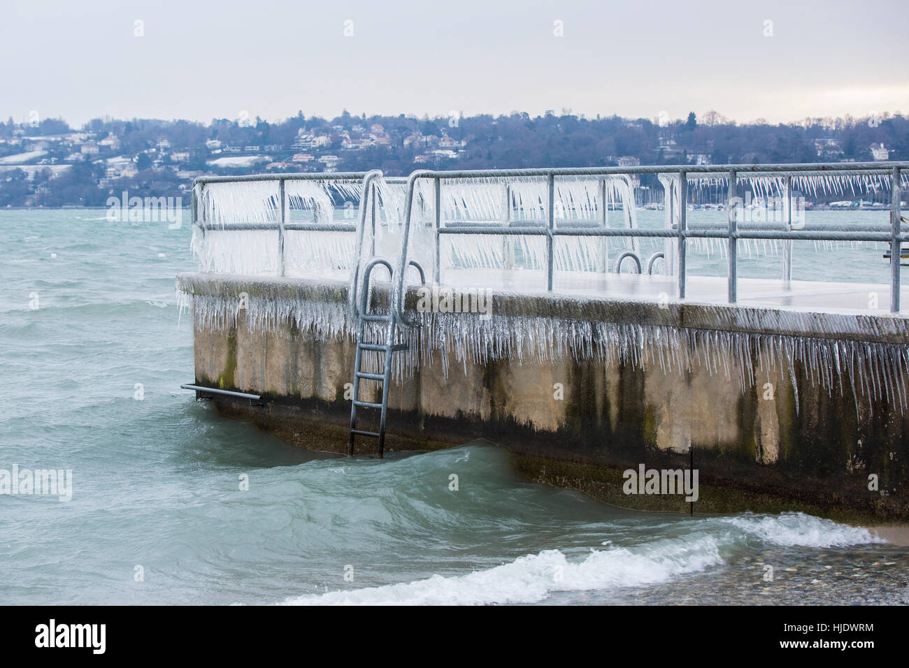 Pier covered with icicles after a winter storm on Lake Geneva. Stock Photo