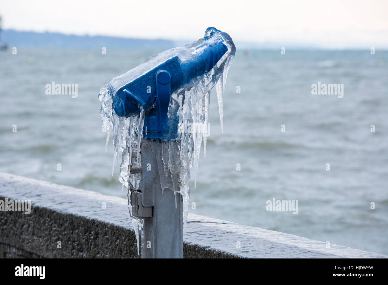 Coin operated binoculars covered with ice following a winter storm on Lake Geneva, Switzerland. Stock Photo
