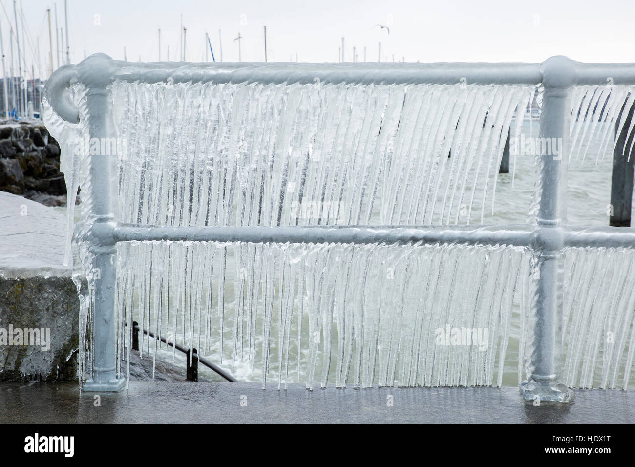 Fence covered with icicles after a winter storm on Lake Geneva. Stock Photo