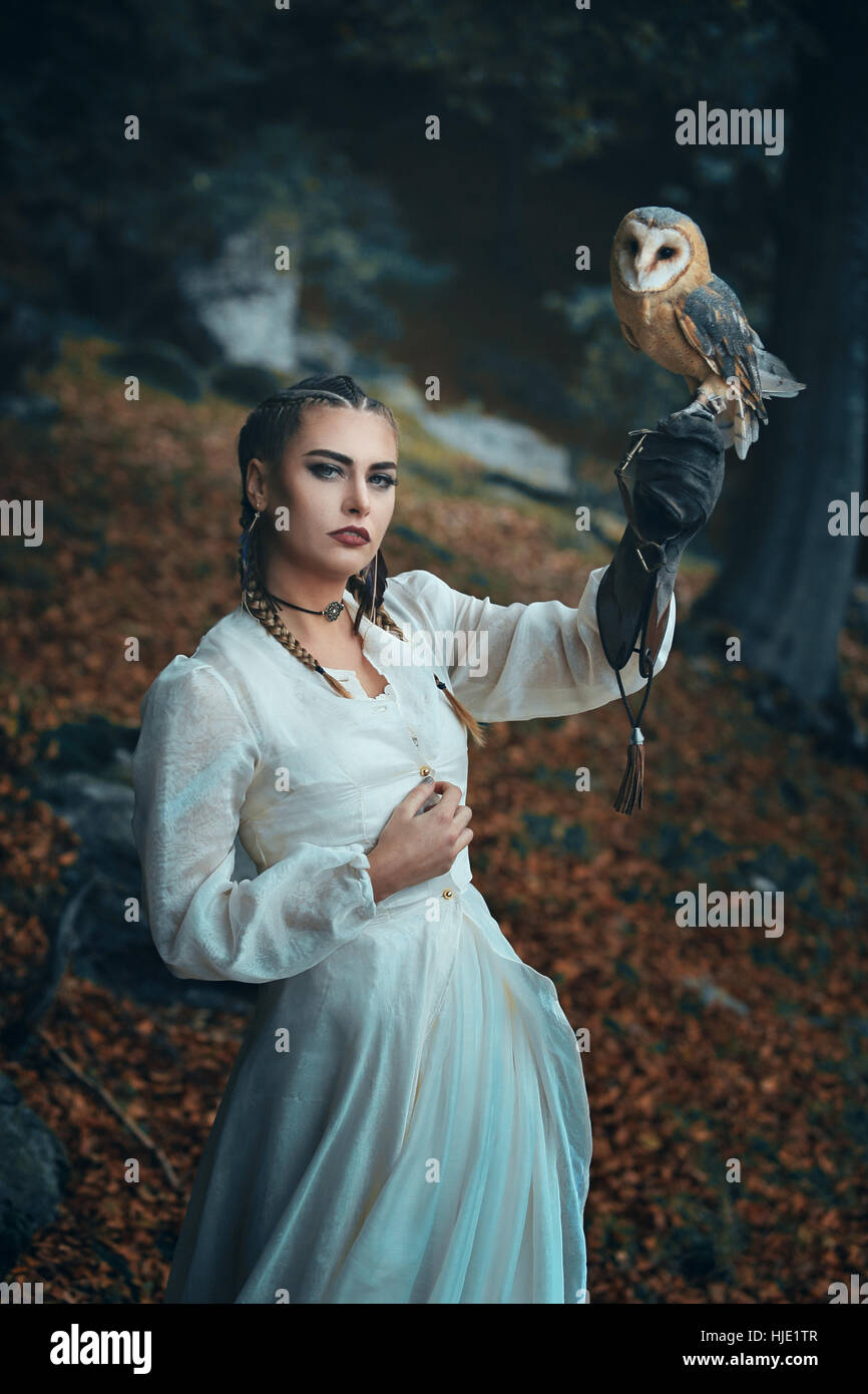 Elegant dressed woman with barn owl . Fantasy and falconry Stock Photo