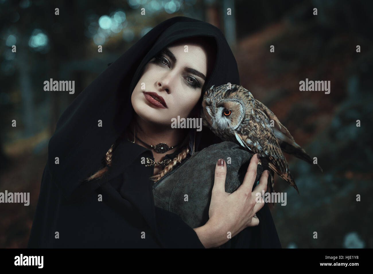 Dark witch of the forest with her owl familiar. Fantasy and fairytale Stock Photo