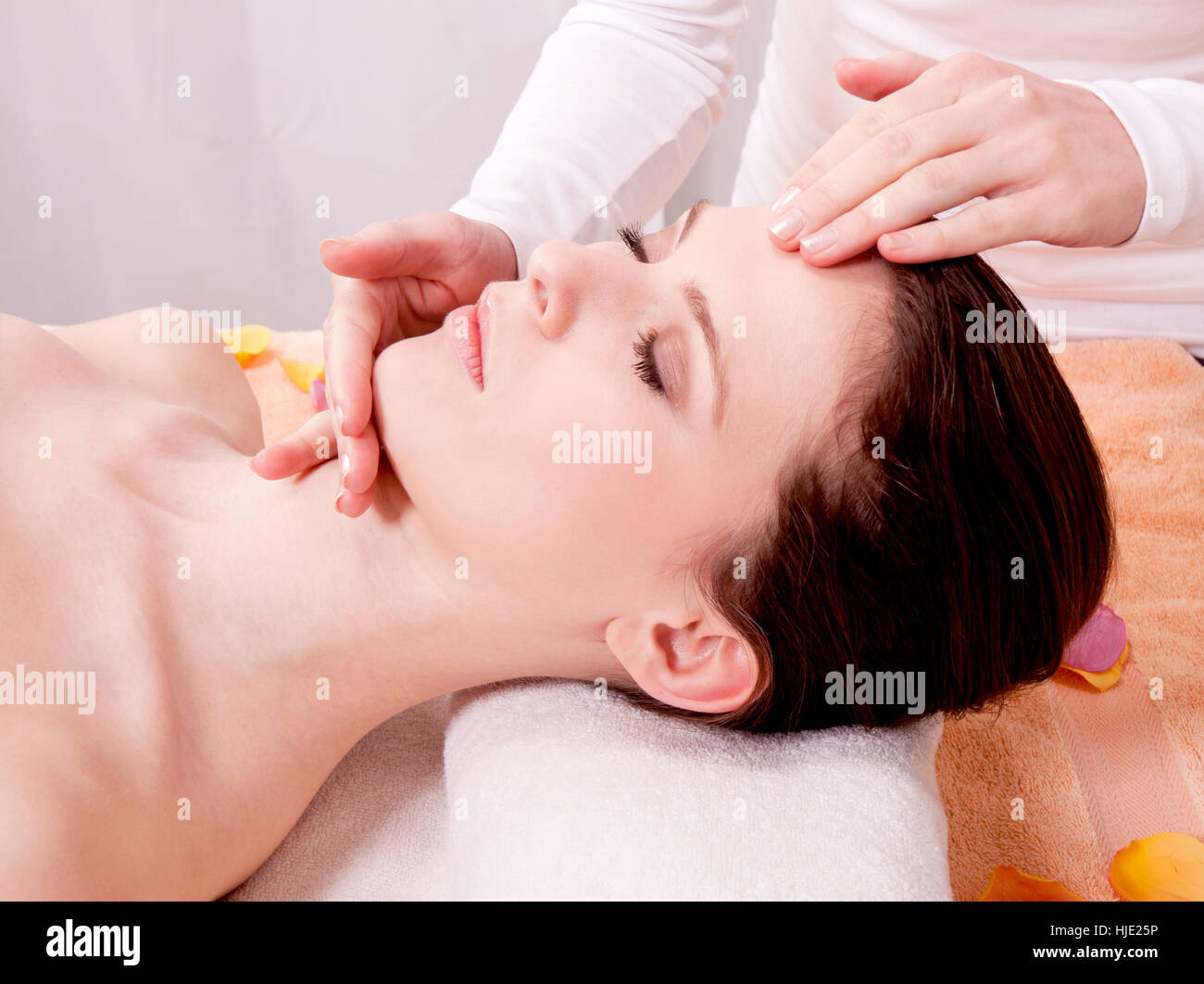 young brunette woman with a relaxing massage of the face Stock Photo
