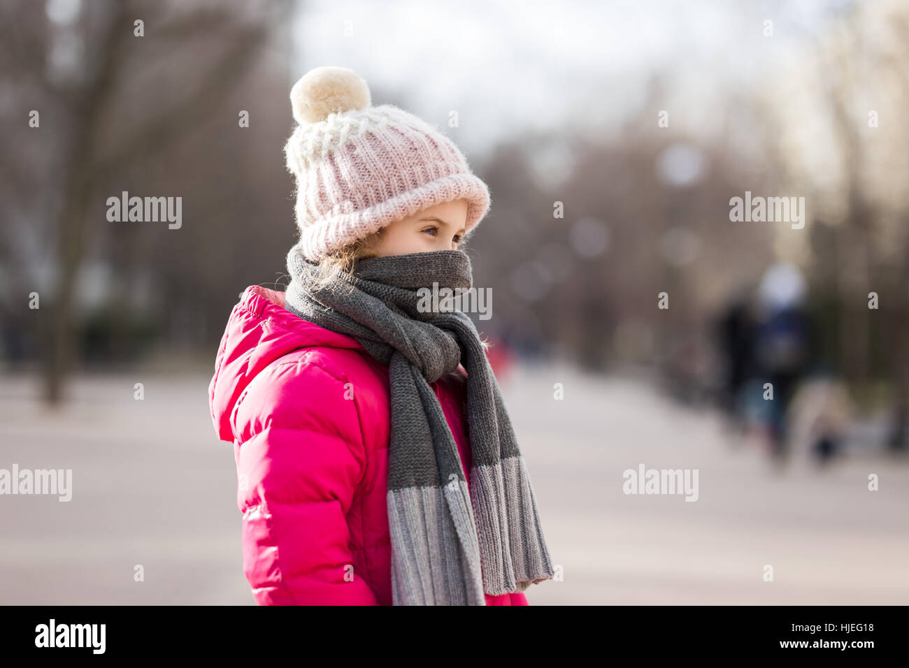 Closeup portrait of cute baby girl wearing knitted hat and winter jacket outdoors Stock Photo