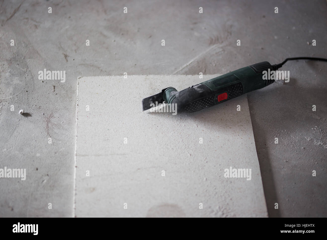 Cutting ceiling plasterboard with electrical multitool Stock Photo Alamy