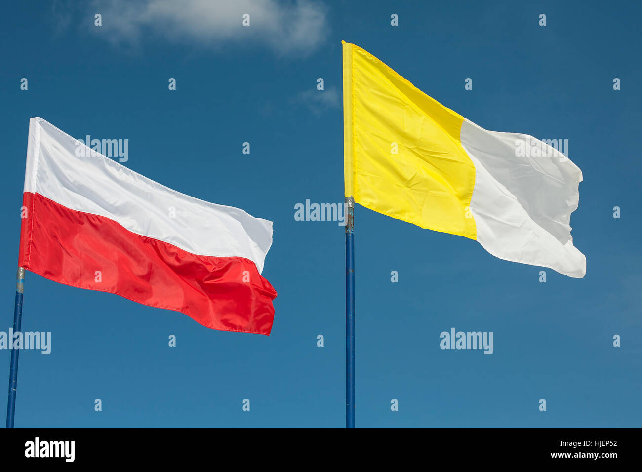 polish and vatican flags in the wind against a sky Stock Photo