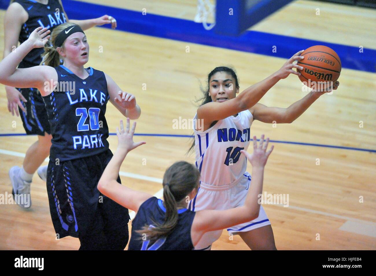 High school player extending to control the basketball while also looking for a passing target from the paint. USA. Stock Photo