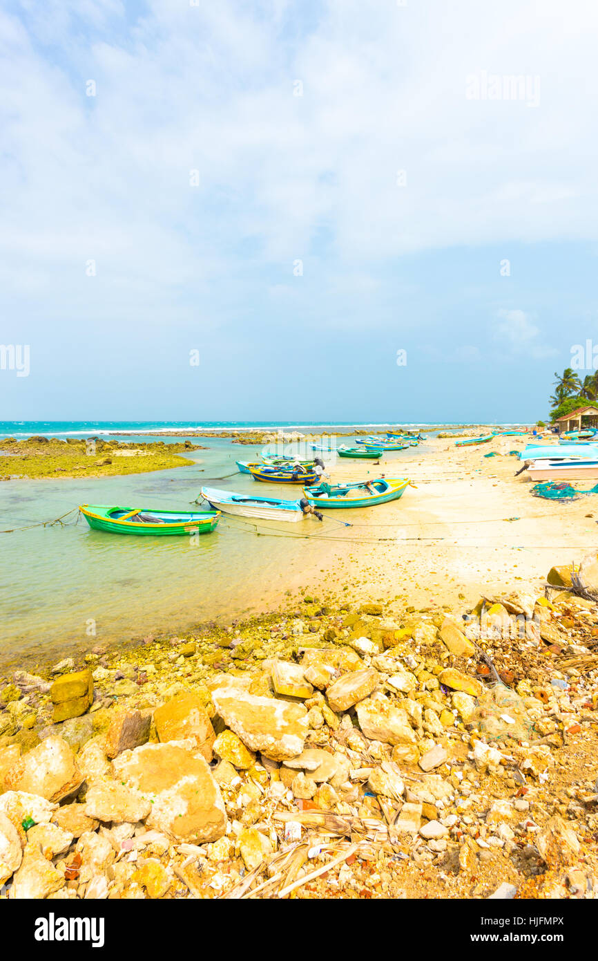 A local fishing village with anchored fishermen's boats on the beach is seen along the northern coast in Jaffna. Vertical Stock Photo