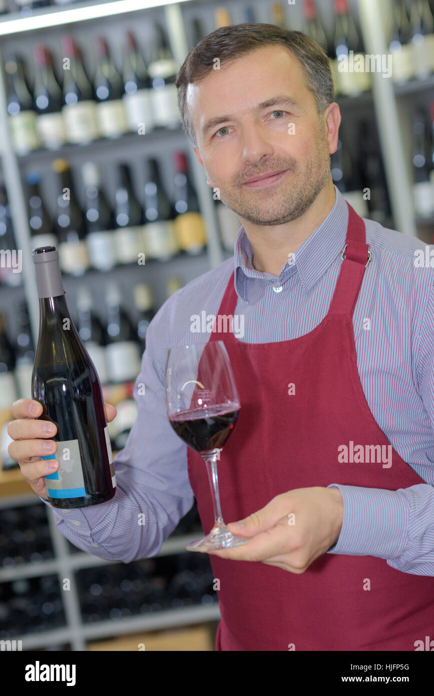 wine merchant showing bottle and glass of wine Stock Photo Alamy
