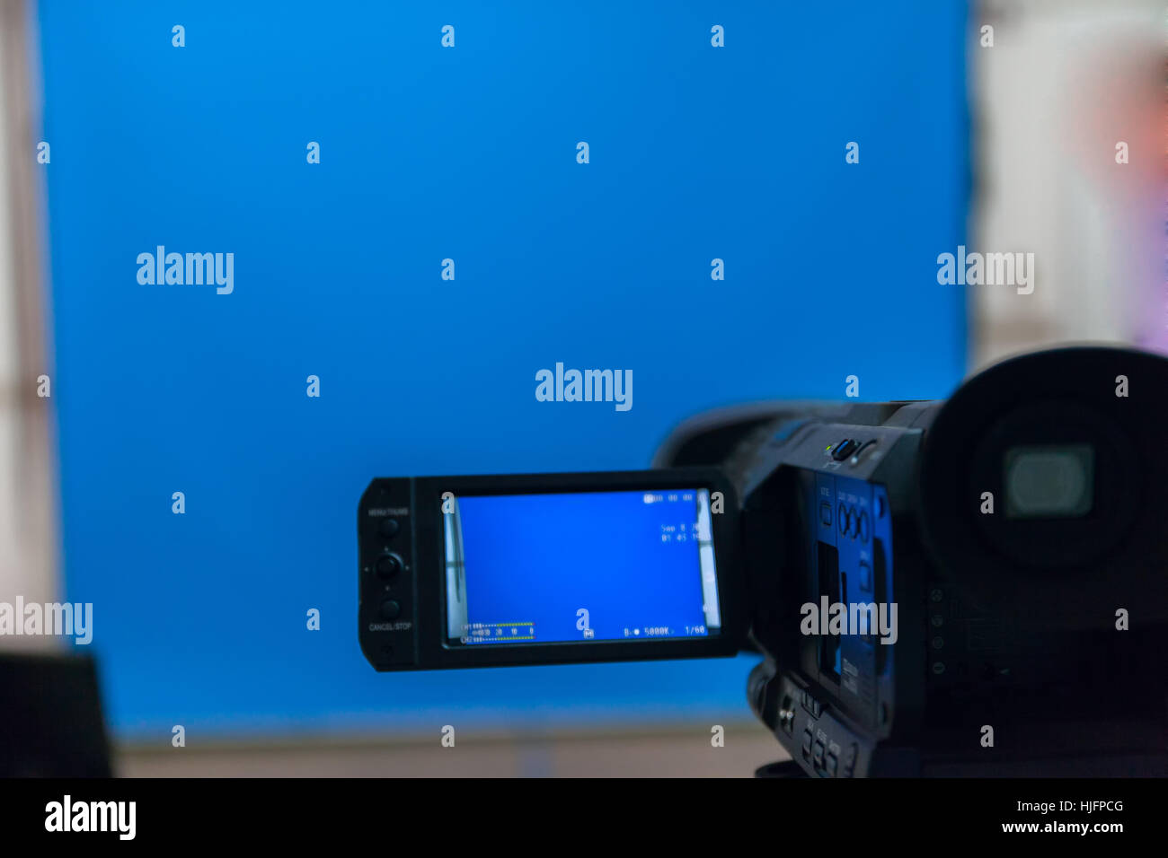 video camera in a studio focused on blue background stock photo Stock Photo