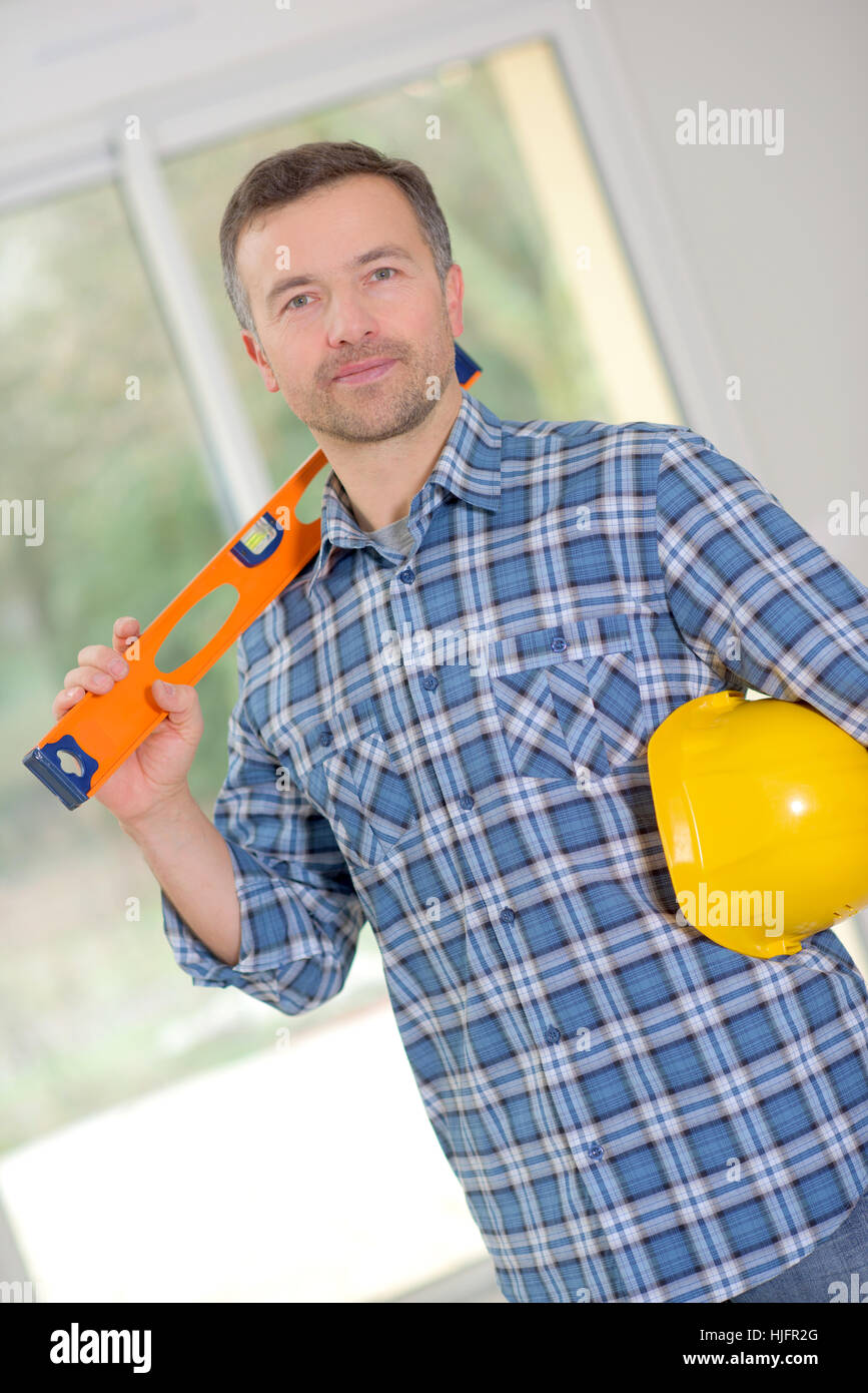 Builder using a spirit level Stock Photo - Alamy