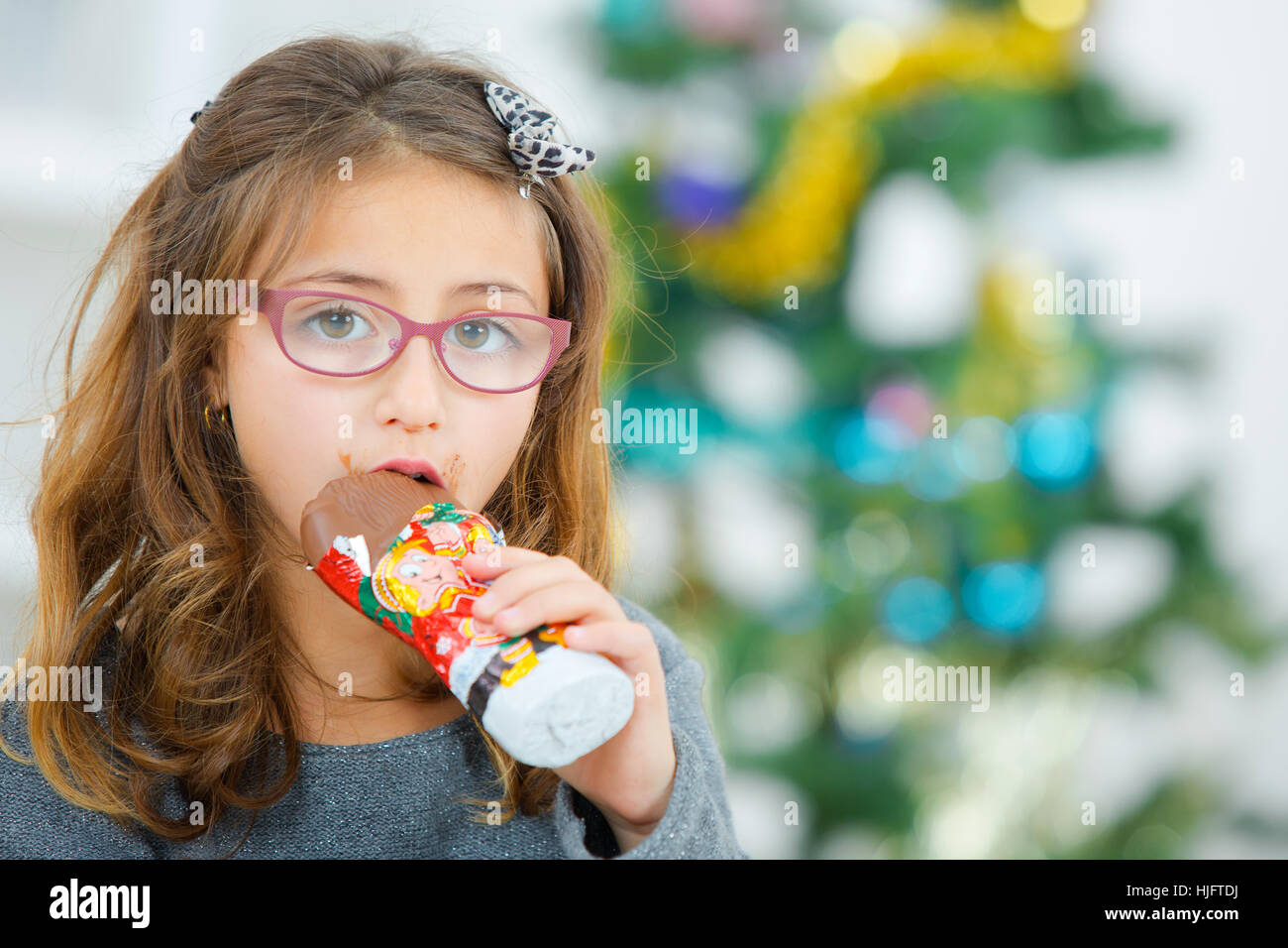 Little girl eating chocolate at Christmas Stock Photo
