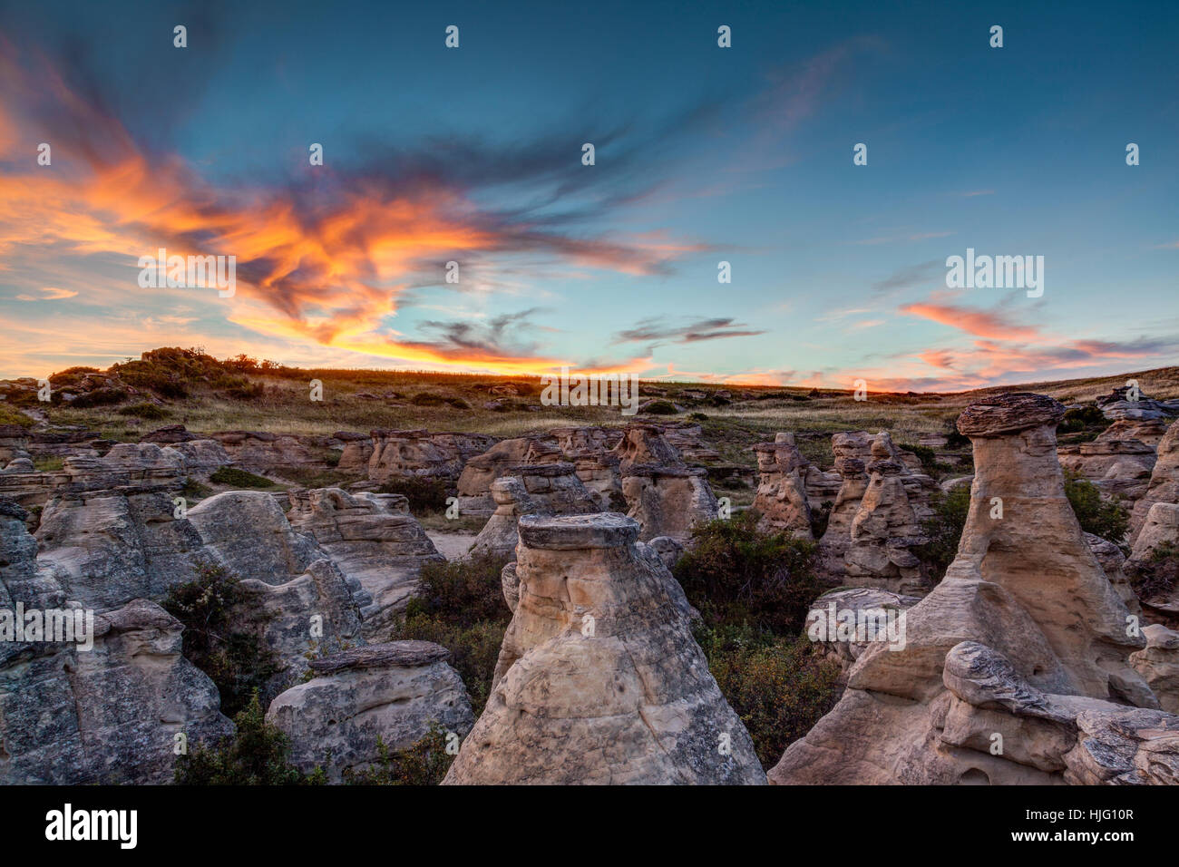 Sunset over the Hoodoo badlands at Writing on Stone Provincial Park and Áísínai'pi National Historic Site in Alberta, Canada. Stock Photo