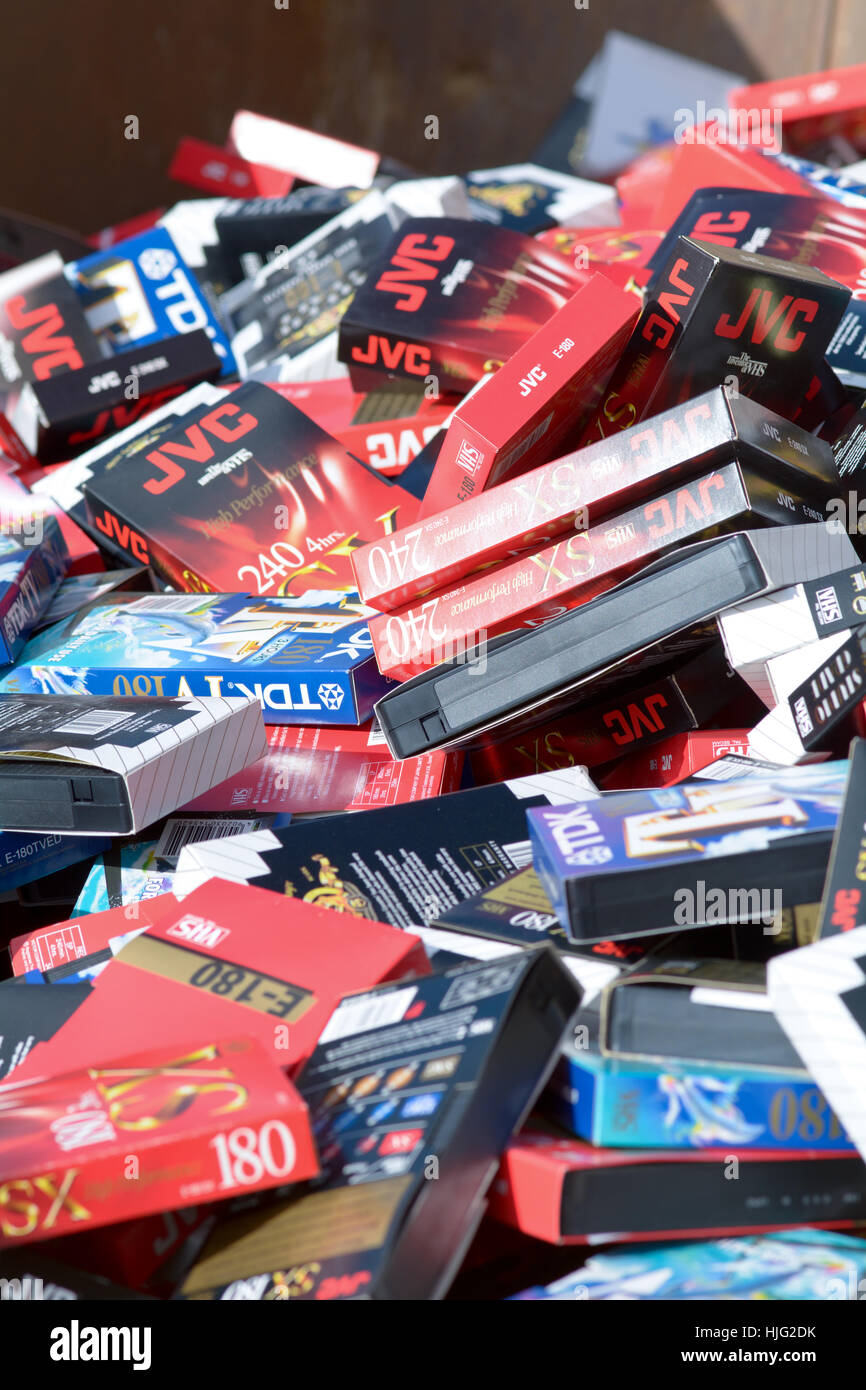 An industrial sized skip full of a huge collection of old obsolete VHS video tapes Stock Photo