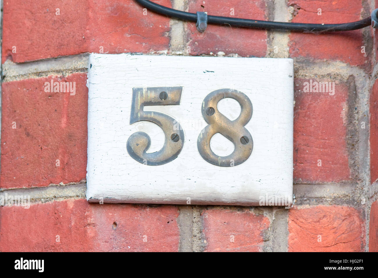 House number 58 sign - brass numbers on wooden block Stock Photo