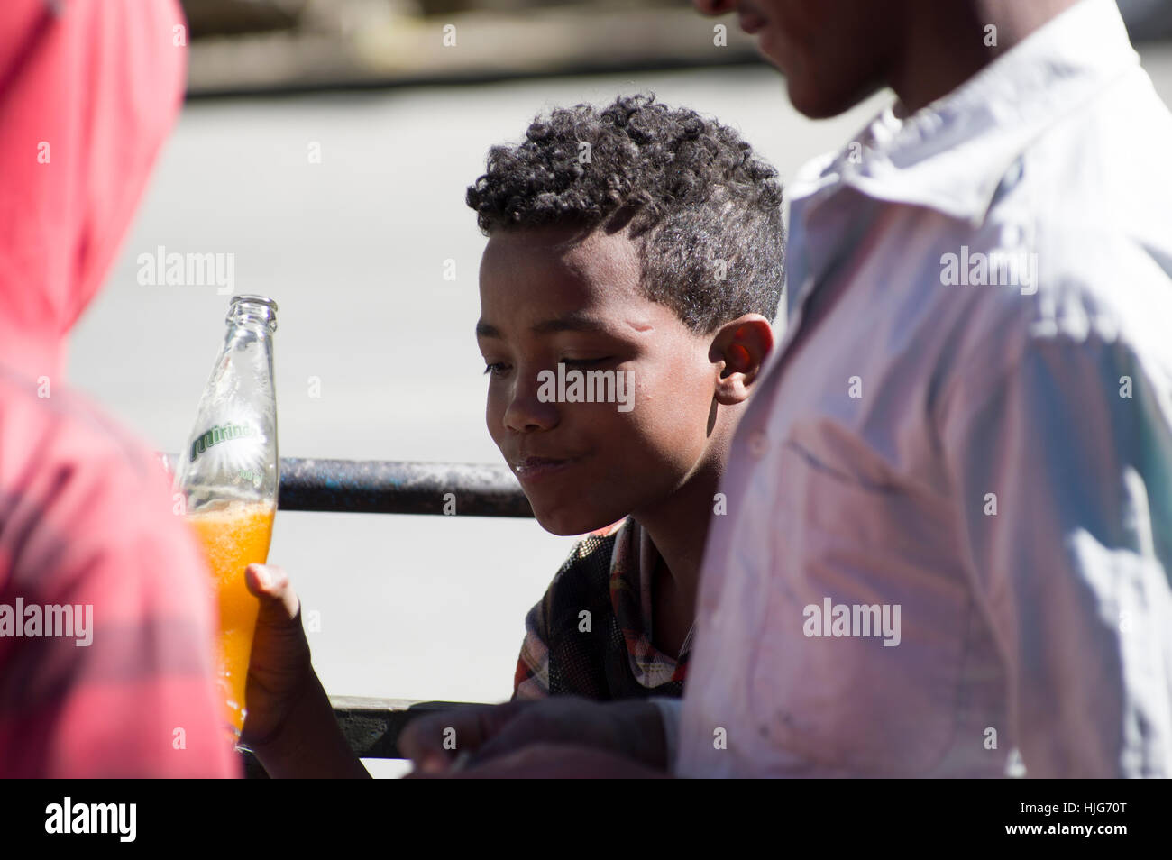 Ethiopian boy smiling with an orange bottle of Miranda Stock Photo