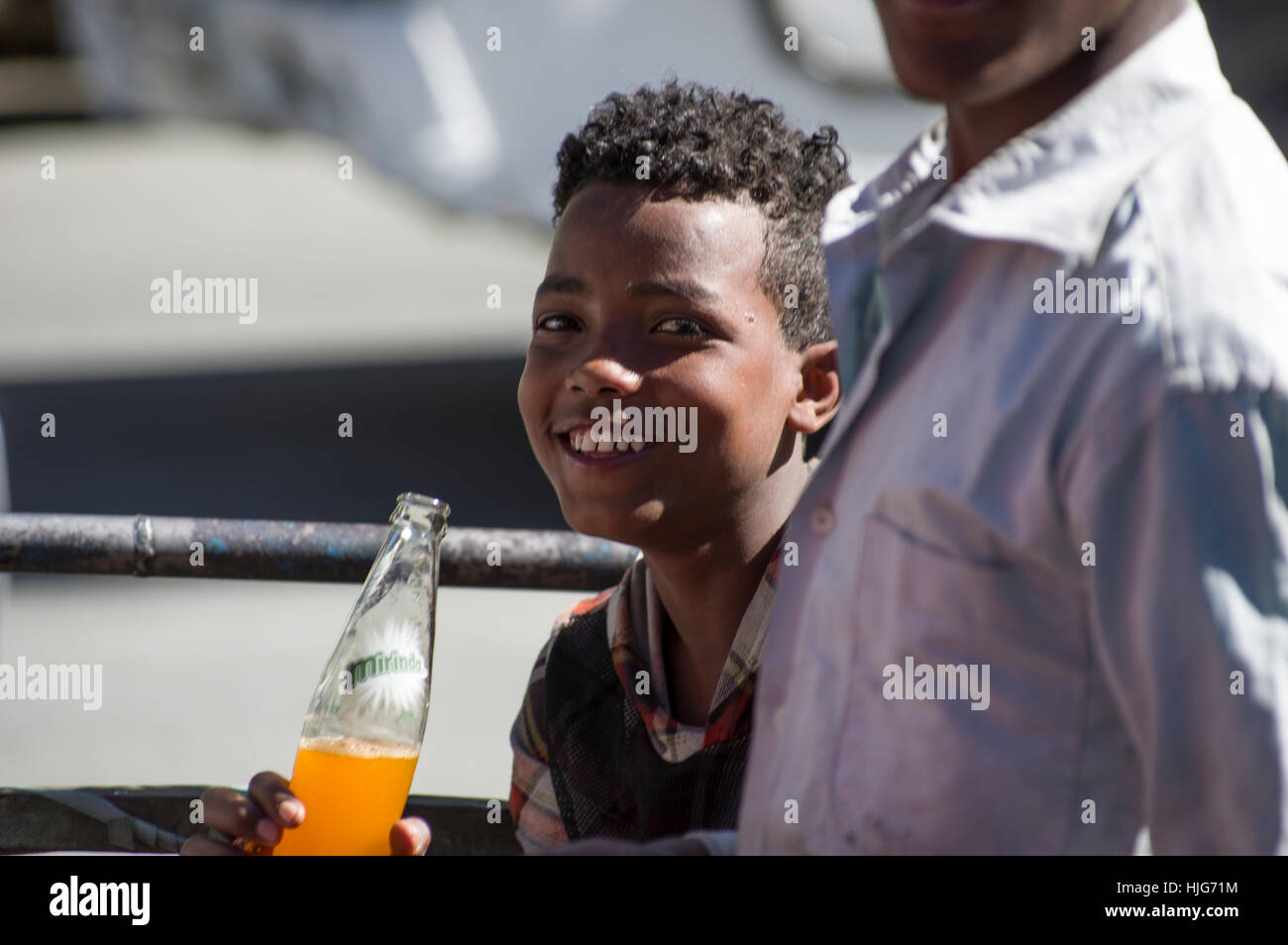 Ethiopian boy smiling with an orange bottle of Miranda Stock Photo