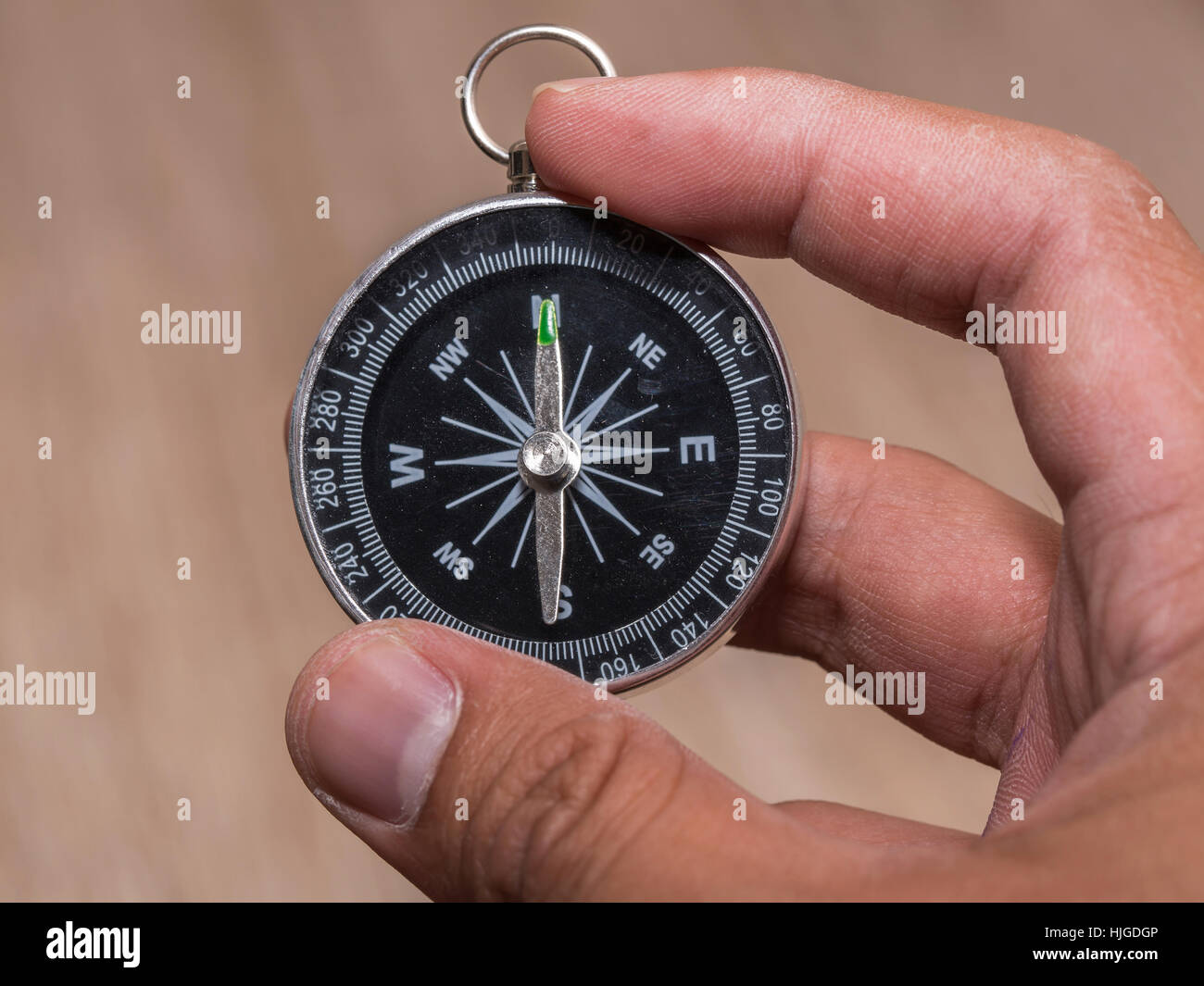 Close up of compass and point to North and hold by hand. Stock Photo
