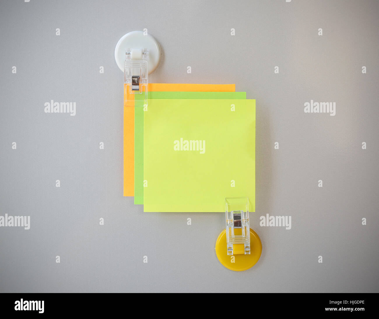 post it clip by white clip magnet on gray refrigerator background for input text. Stock Photo
